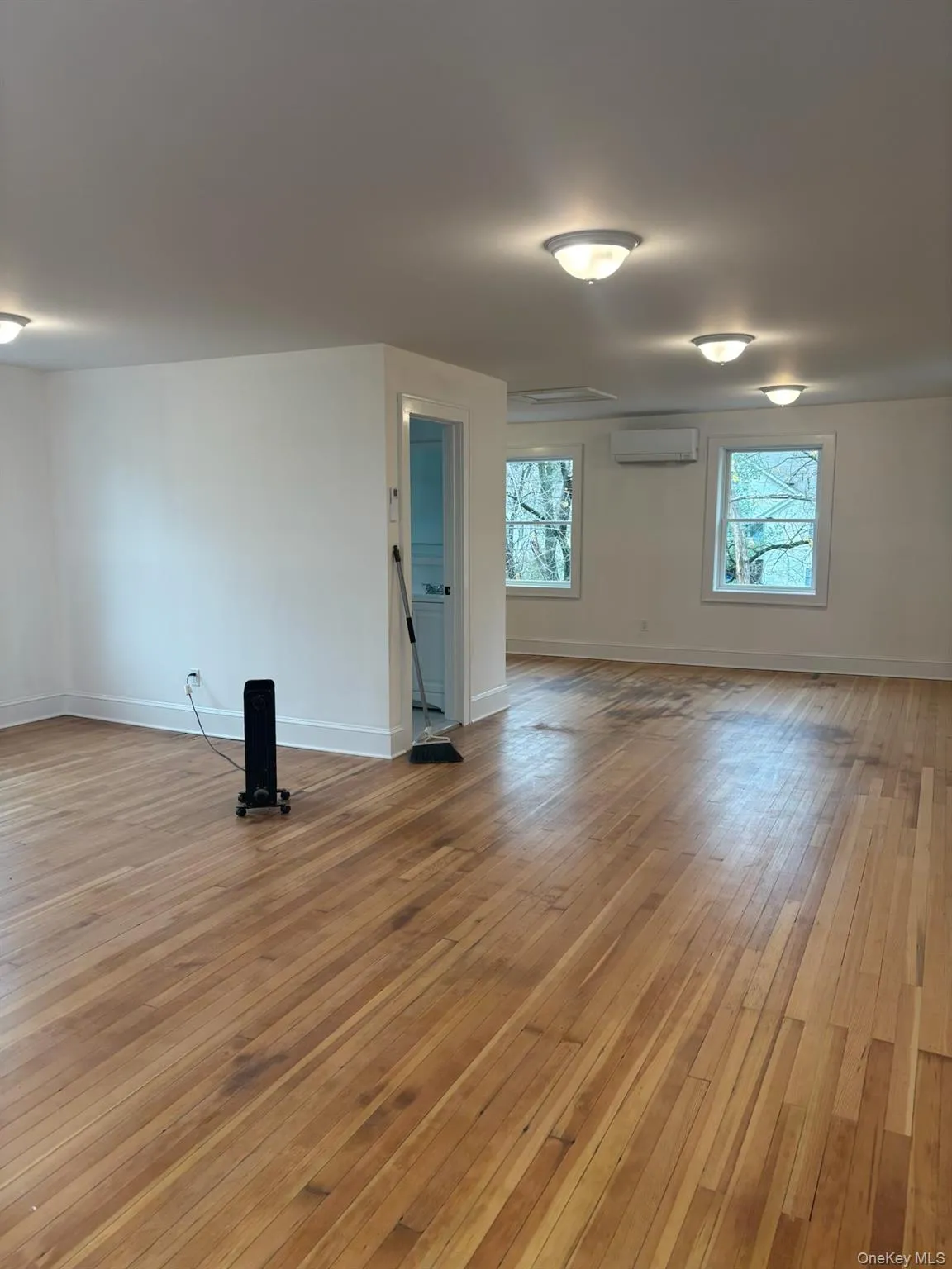 Spare room featuring light wood finished floors and a wall mounted air conditioner Spare room featuring light wood finished floors and a wall mounted air conditioner