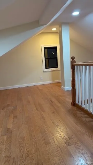 Additional living space with lofted ceiling, light wood-type flooring, and recessed lighting Additional living space with lofted ceiling, light wood-type flooring, and recessed lighting