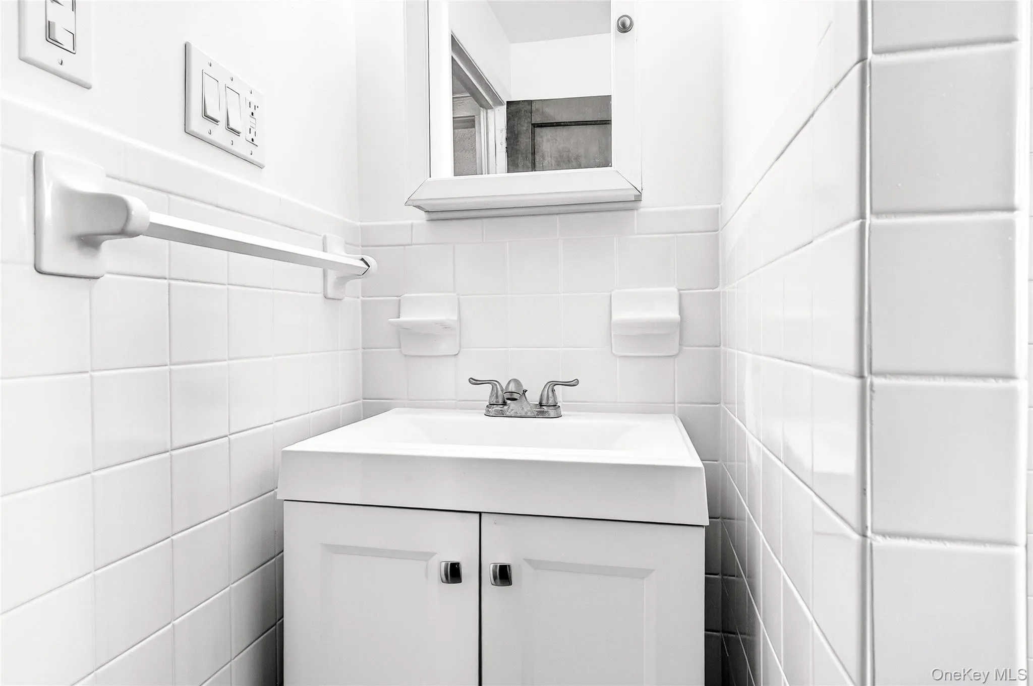 Bathroom featuring vanity and tile walls Bathroom featuring vanity and tile walls