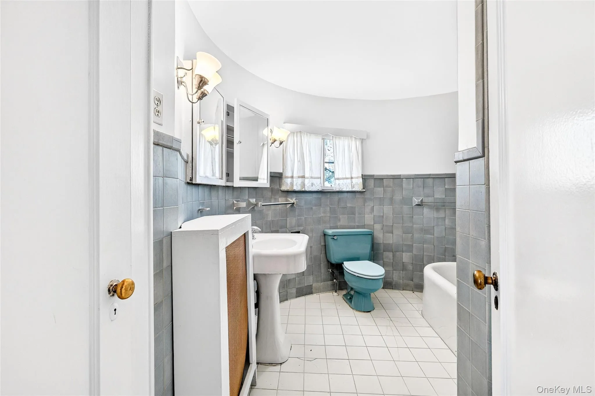 Bathroom featuring light tile patterned floors, tile walls, and wainscoting Bathroom featuring light tile patterned floors, tile walls, and wainscoting