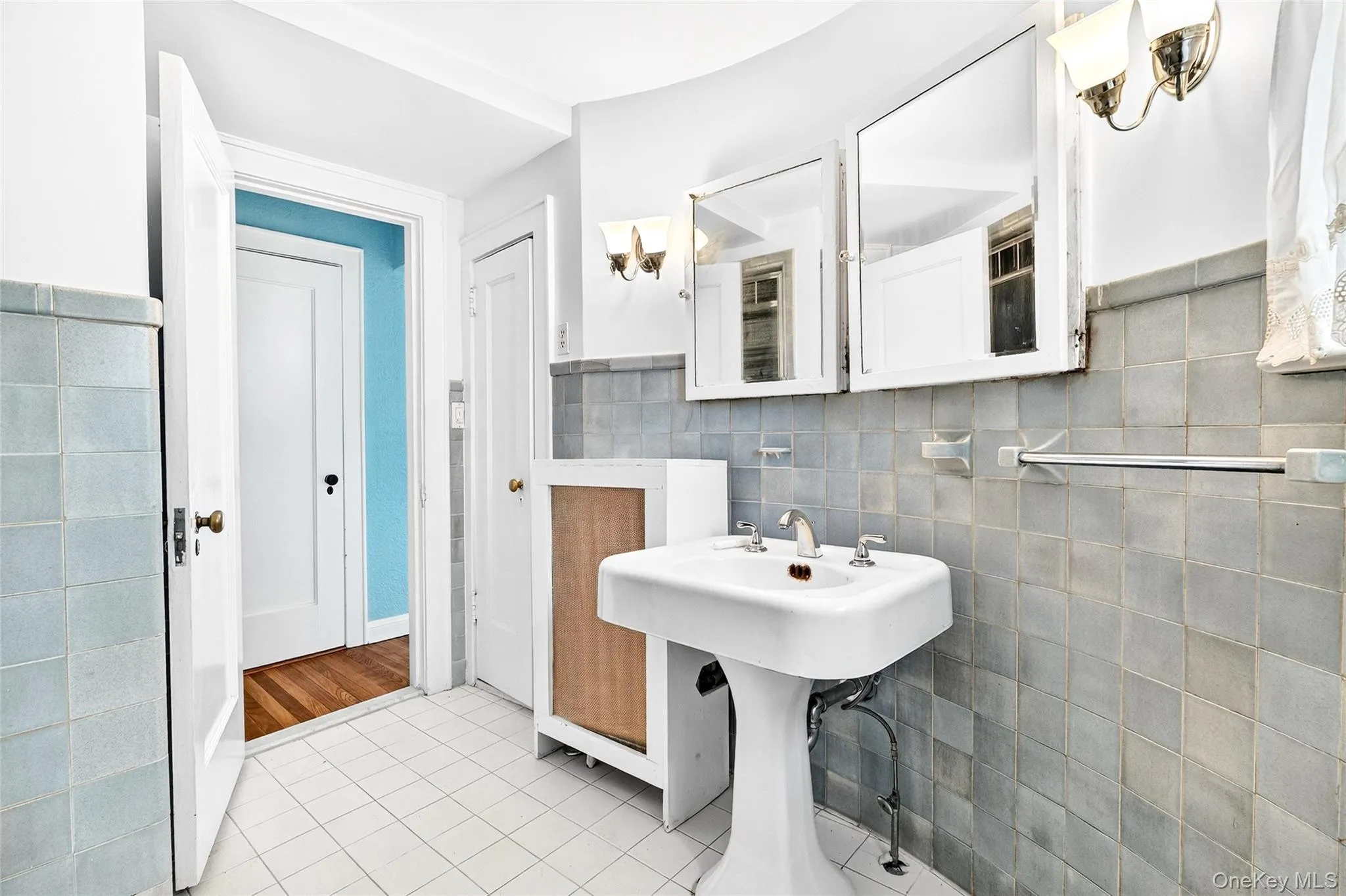 Bathroom with tile walls, light tile patterned floors, and a wainscoted wall Bathroom with tile walls, light tile patterned floors, and a wainscoted wall