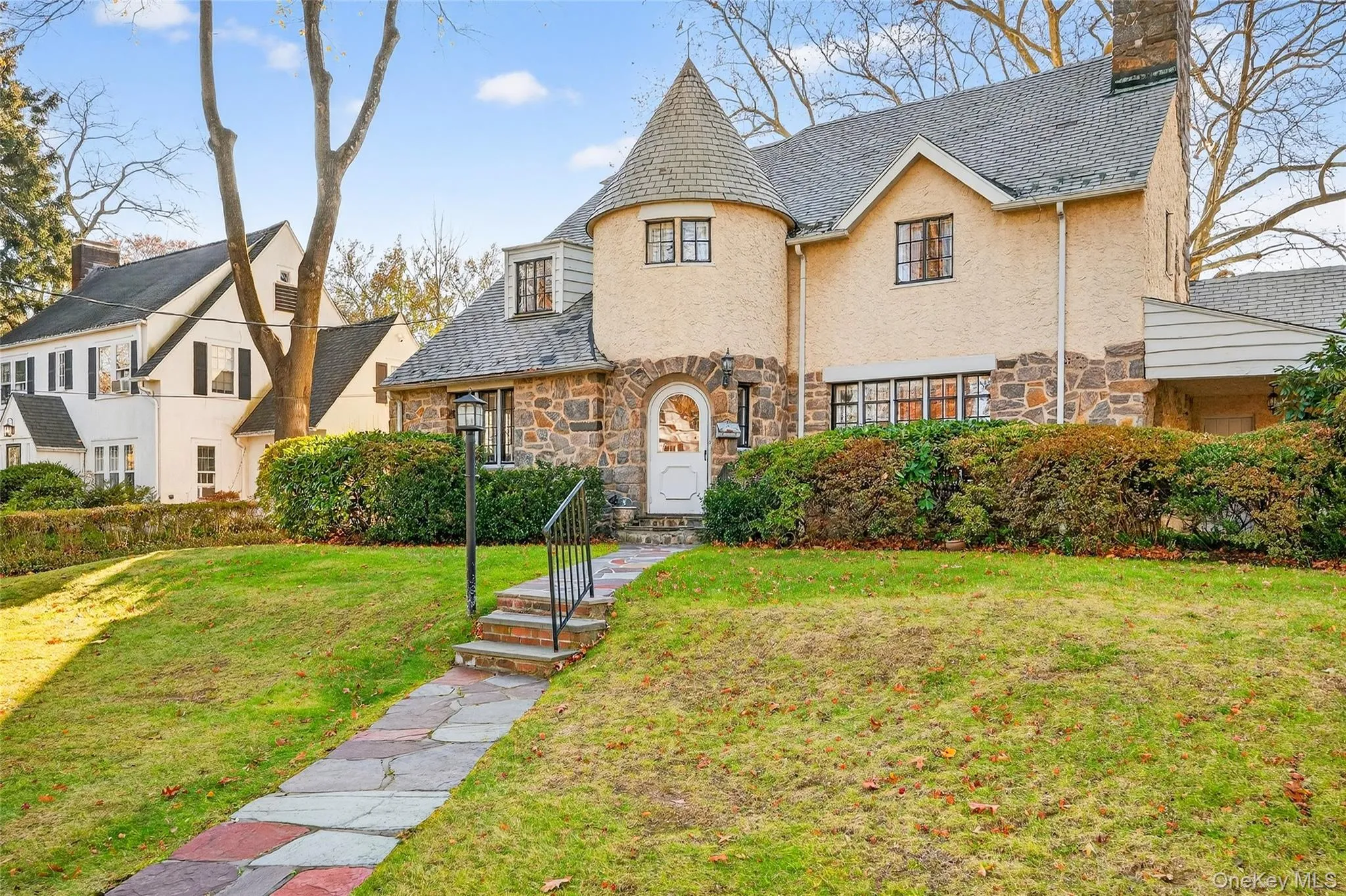 View of front of property featuring stone siding, a front lawn, and a chimney View of front of property featuring stone siding, a front lawn, and a chimney
