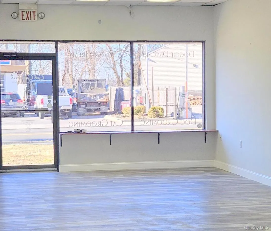 lobby featuring healthy amount of natural light, a drop ceiling, and wood finished floors lobby featuring healthy amount of natural light, a drop ceiling, and wood finished floors