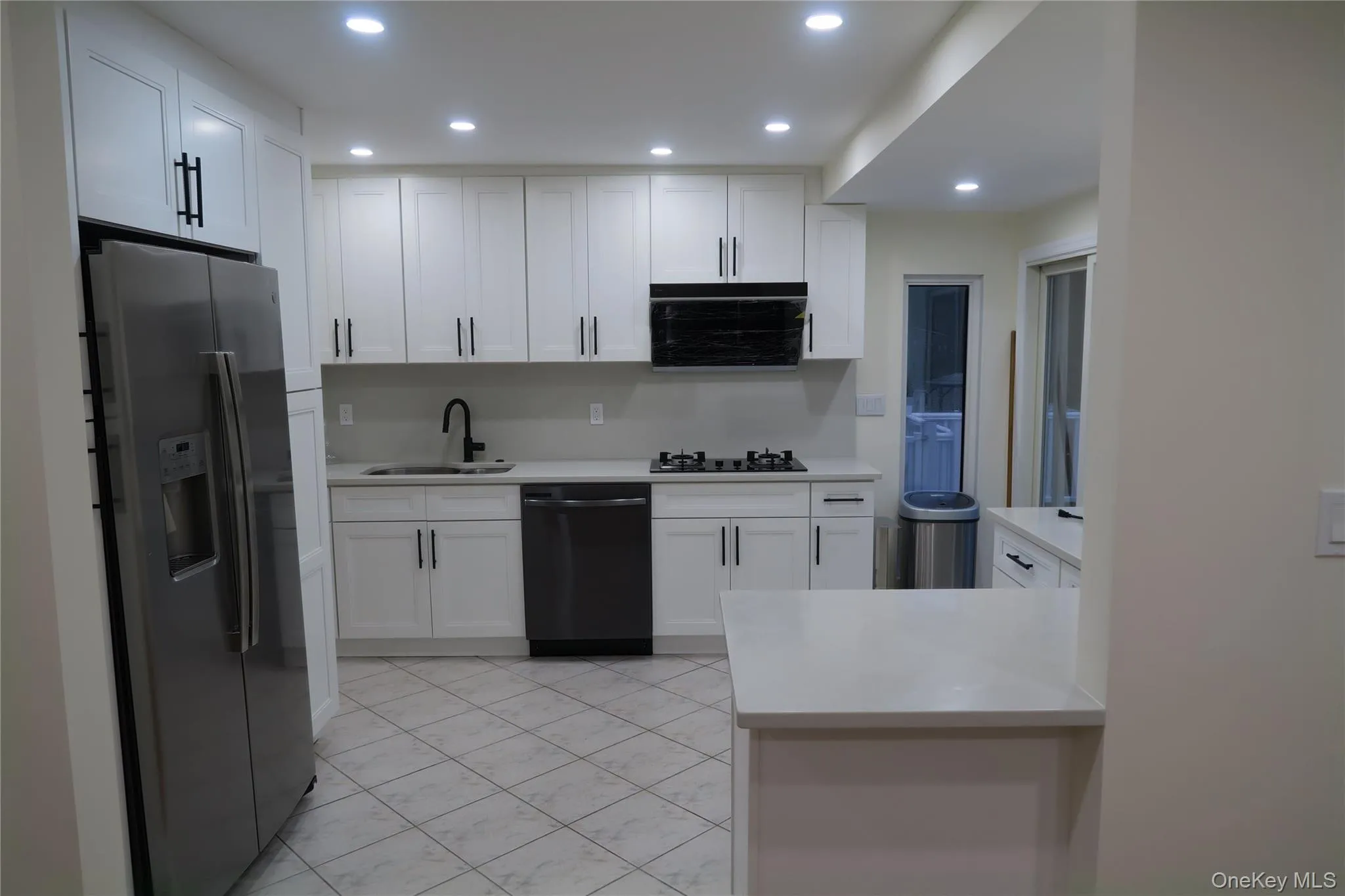 Kitchen with stainless steel refrigerator with ice dispenser, white cabinets, dishwasher, recessed lighting, and light stone countertops Kitchen with stainless steel refrigerator with ice dispenser, white cabinets, dishwasher, recessed lighting, and light stone countertops