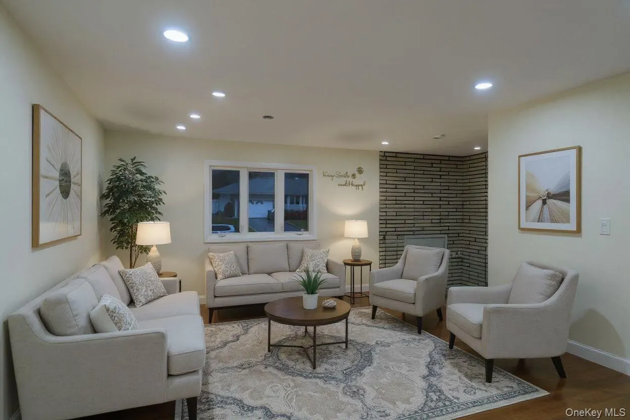Living area with recessed lighting, wood finished floors, and a brick fireplace Living area with recessed lighting, wood finished floors, and a brick fireplace