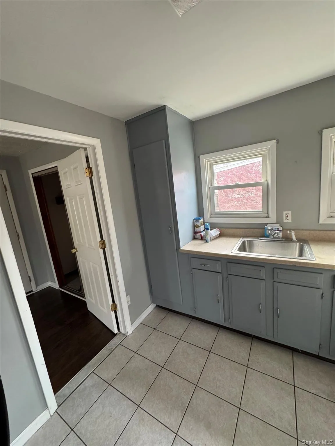 Kitchen featuring light countertops, gray cabinets, and light tile patterned floors Kitchen featuring light countertops, gray cabinets, and light tile patterned floors