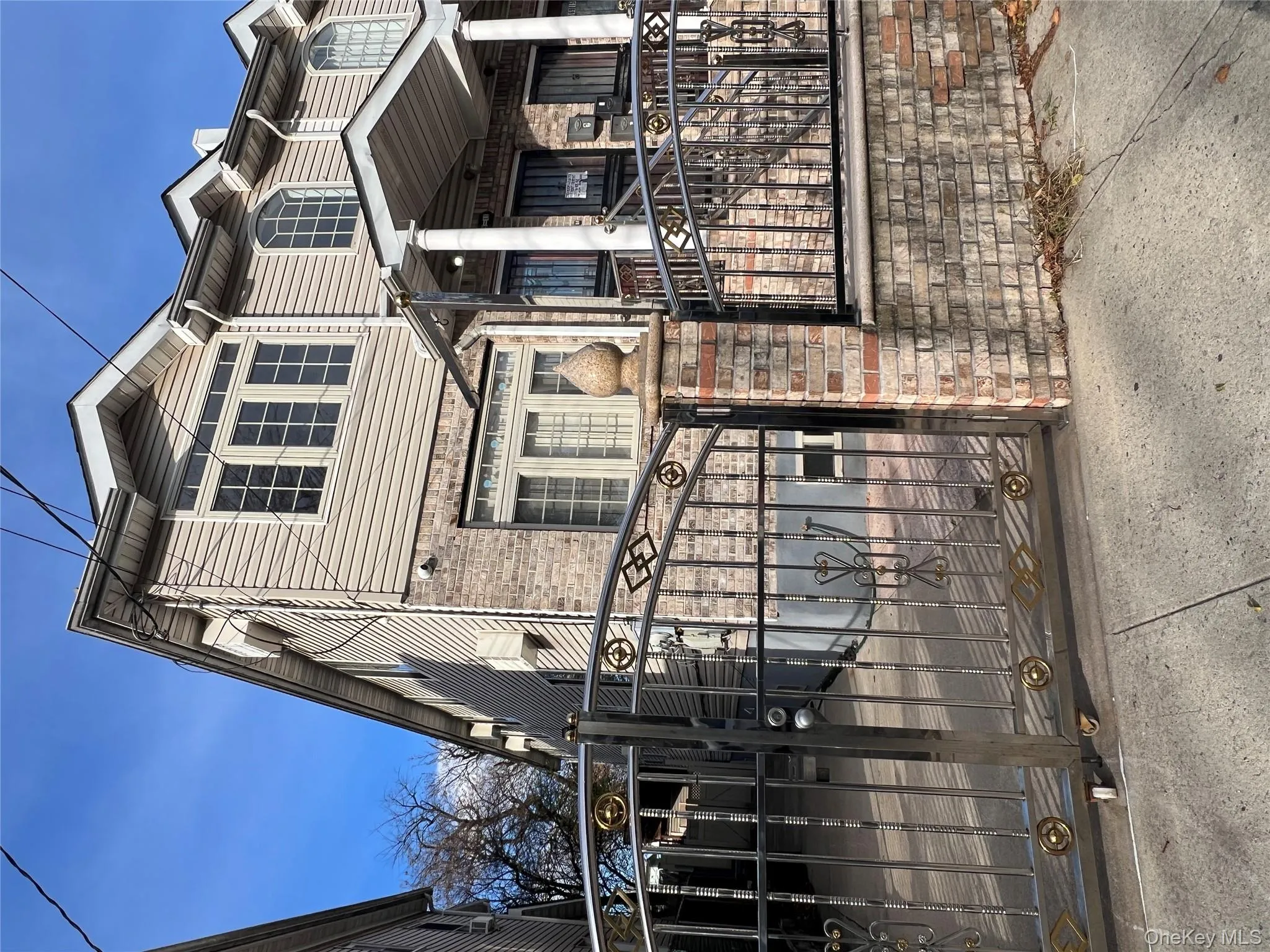 View of front facade featuring a gate, brick siding, and covered porch View of front facade featuring a gate, brick siding, and covered porch