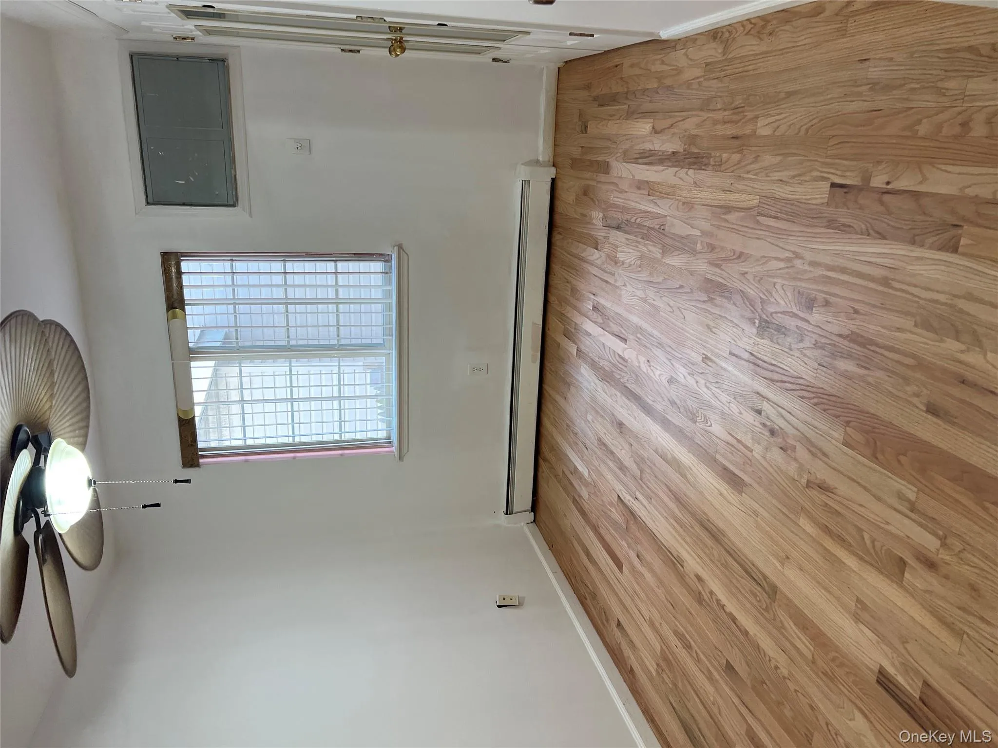 Spare room with light wood-style flooring, ceiling fan, and baseboard heating Spare room with light wood-style flooring, ceiling fan, and baseboard heating