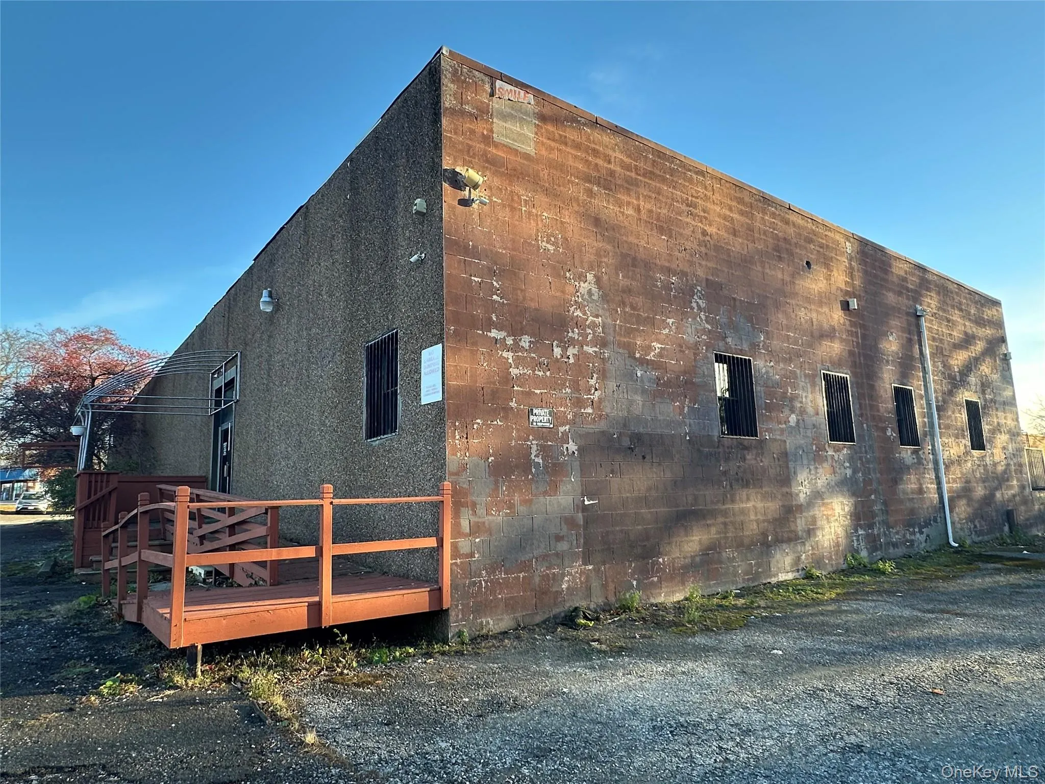 View of side of property featuring a wooden deck and concrete block siding View of side of property featuring a wooden deck and concrete block siding