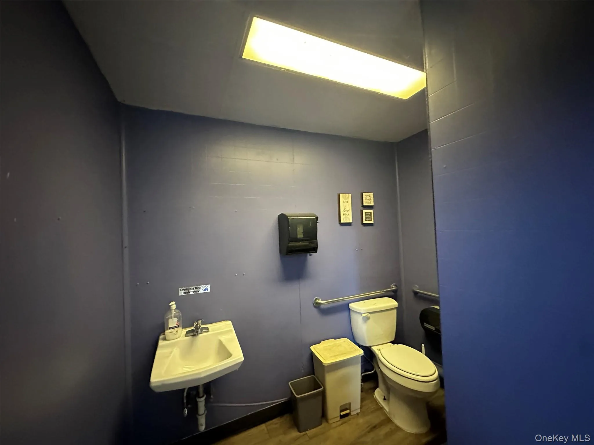 Half bath with wood finished floors and tile walls Half bath with wood finished floors and tile walls