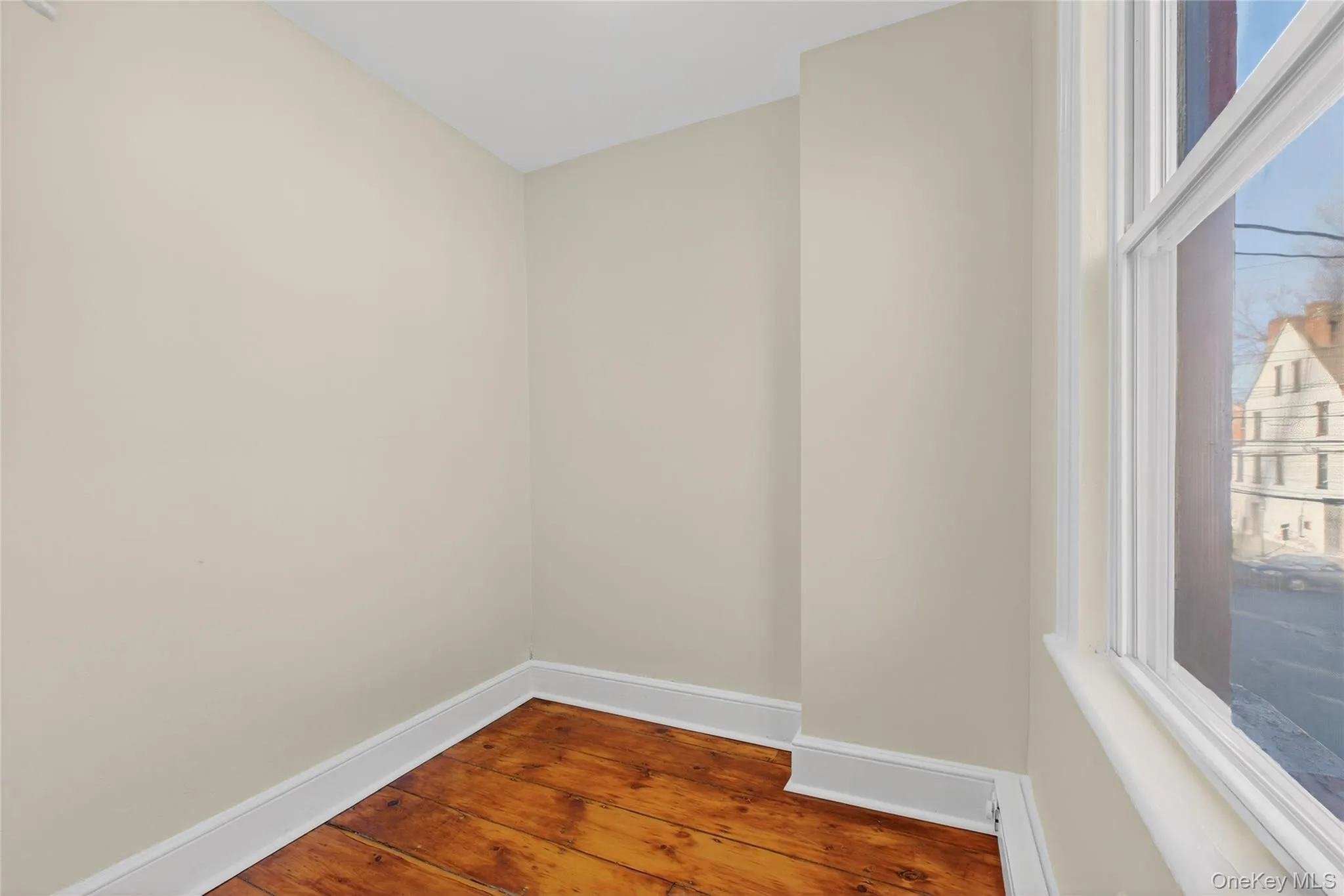Empty room featuring hardwood / wood-style floors and baseboard heating Empty room featuring hardwood / wood-style floors and baseboard heating