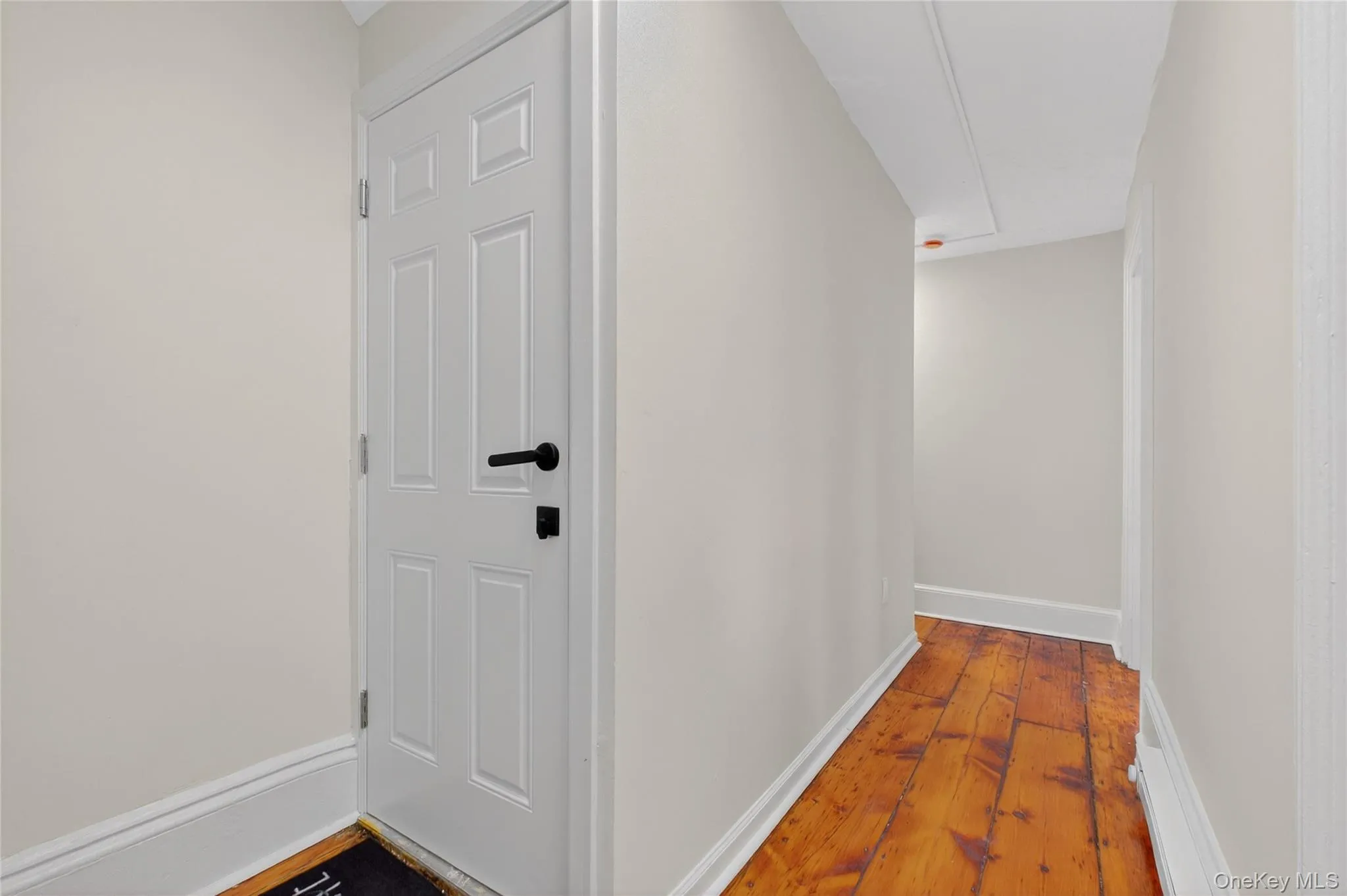 Hallway featuring baseboards and hardwood / wood-style floors Hallway featuring baseboards and hardwood / wood-style floors