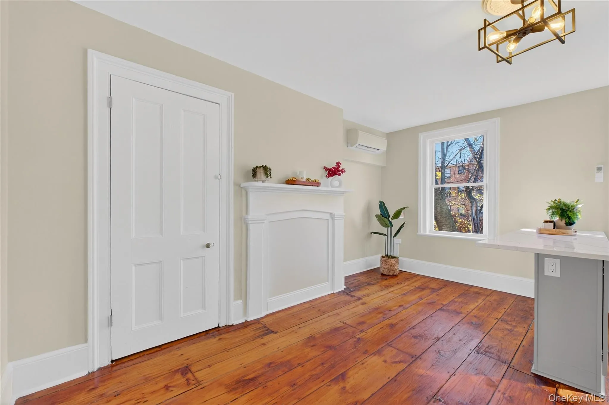 Dining room with dark wood-type flooring, a wall mounted air conditioner, and a chandelier Dining room with dark wood-type flooring, a wall mounted air conditioner, and a chandelier