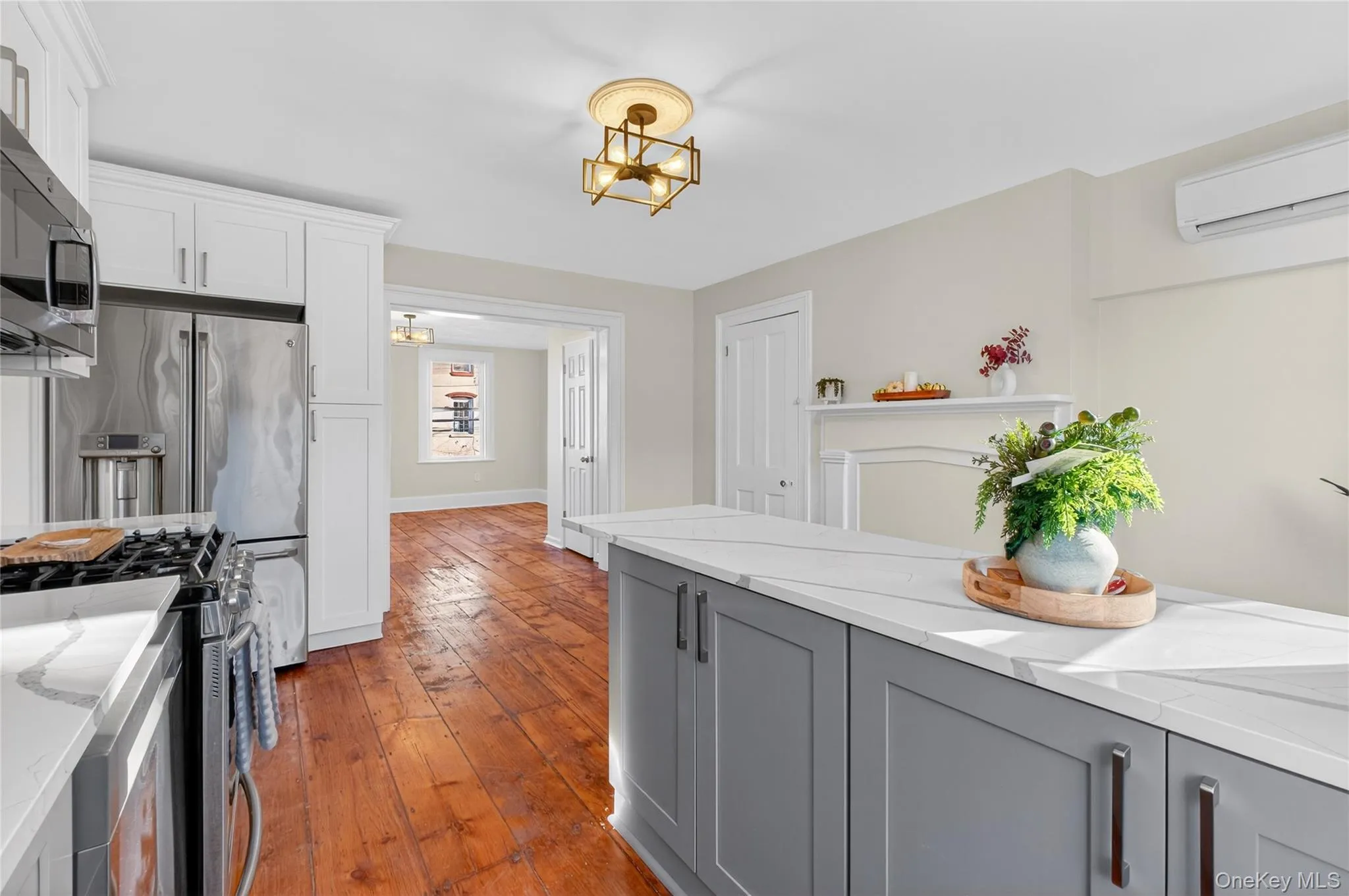 Kitchen featuring gray cabinetry, appliances with stainless steel finishes, light stone countertops, and white cabinetry Kitchen featuring gray cabinetry, appliances with stainless steel finishes, light stone countertops, and white cabinetry