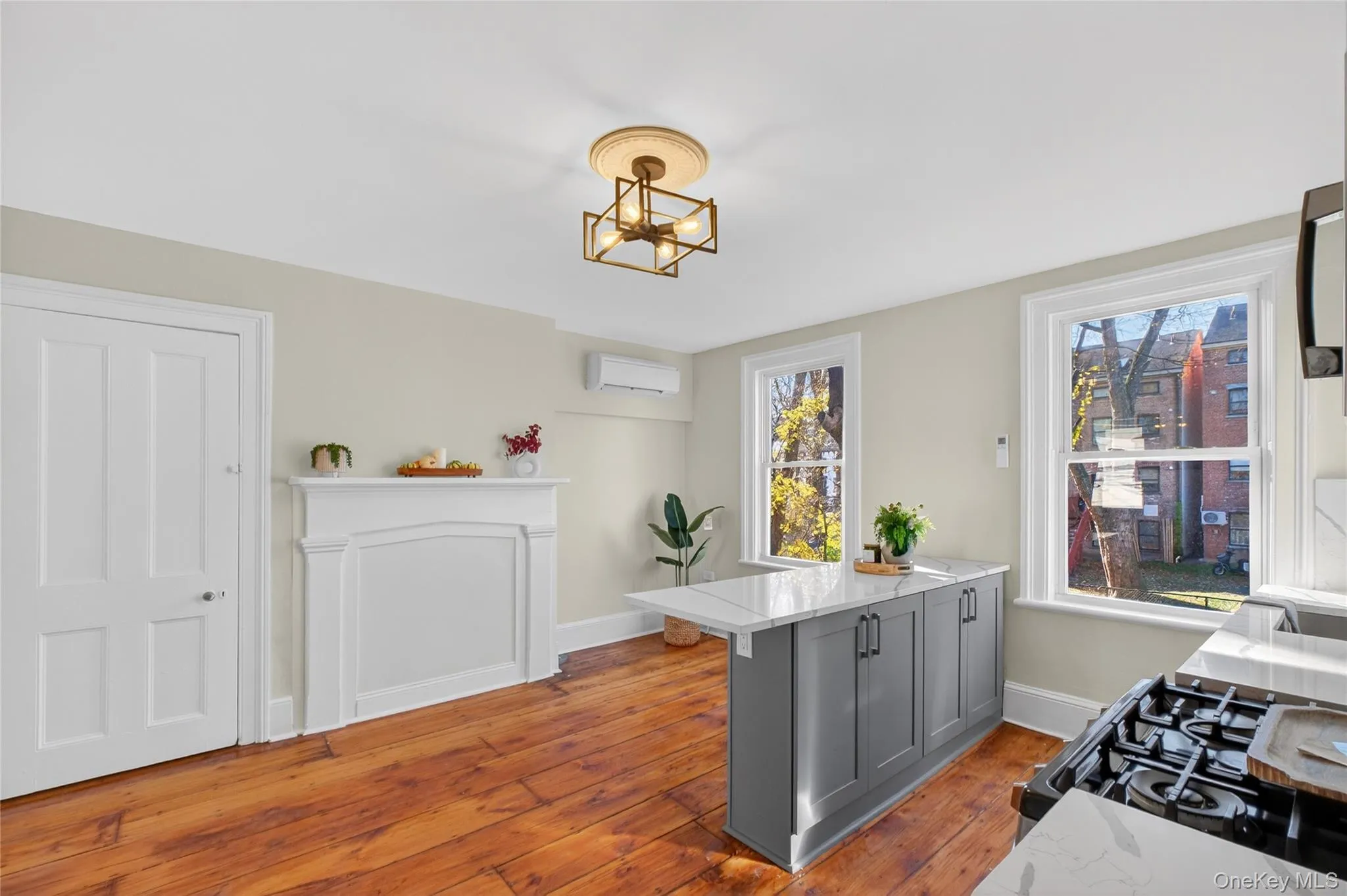 Kitchen featuring a peninsula, gas stove, gray cabinets, and light wood-style flooring Kitchen featuring a peninsula, gas stove, gray cabinets, and light wood-style flooring