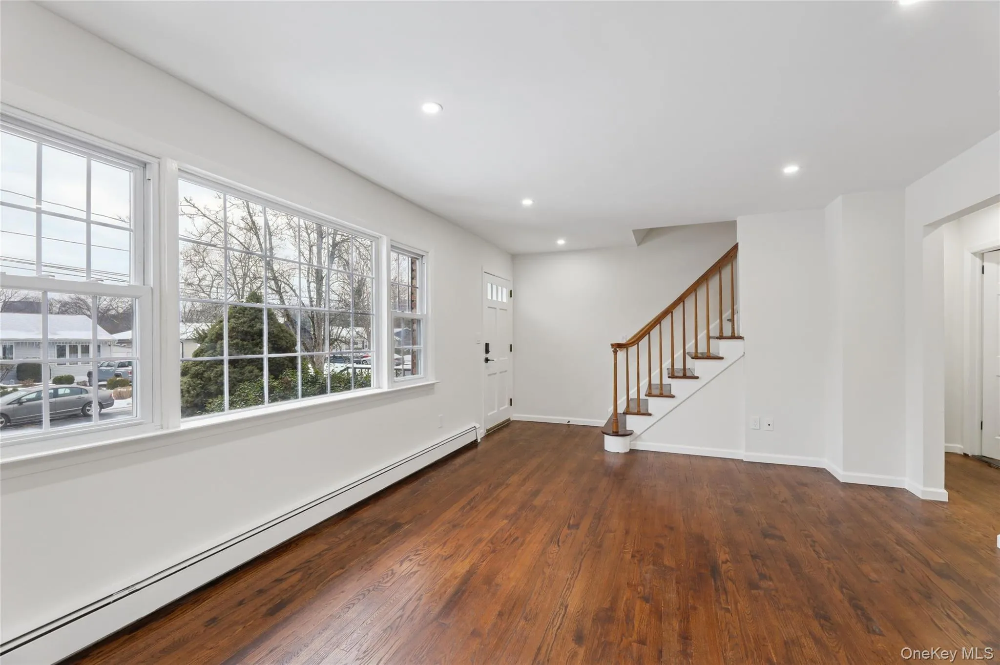 Foyer entrance with a baseboard heating unit, stairway, recessed lighting, and dark wood-type flooring Foyer entrance with a baseboard heating unit, stairway, recessed lighting, and dark wood-type flooring