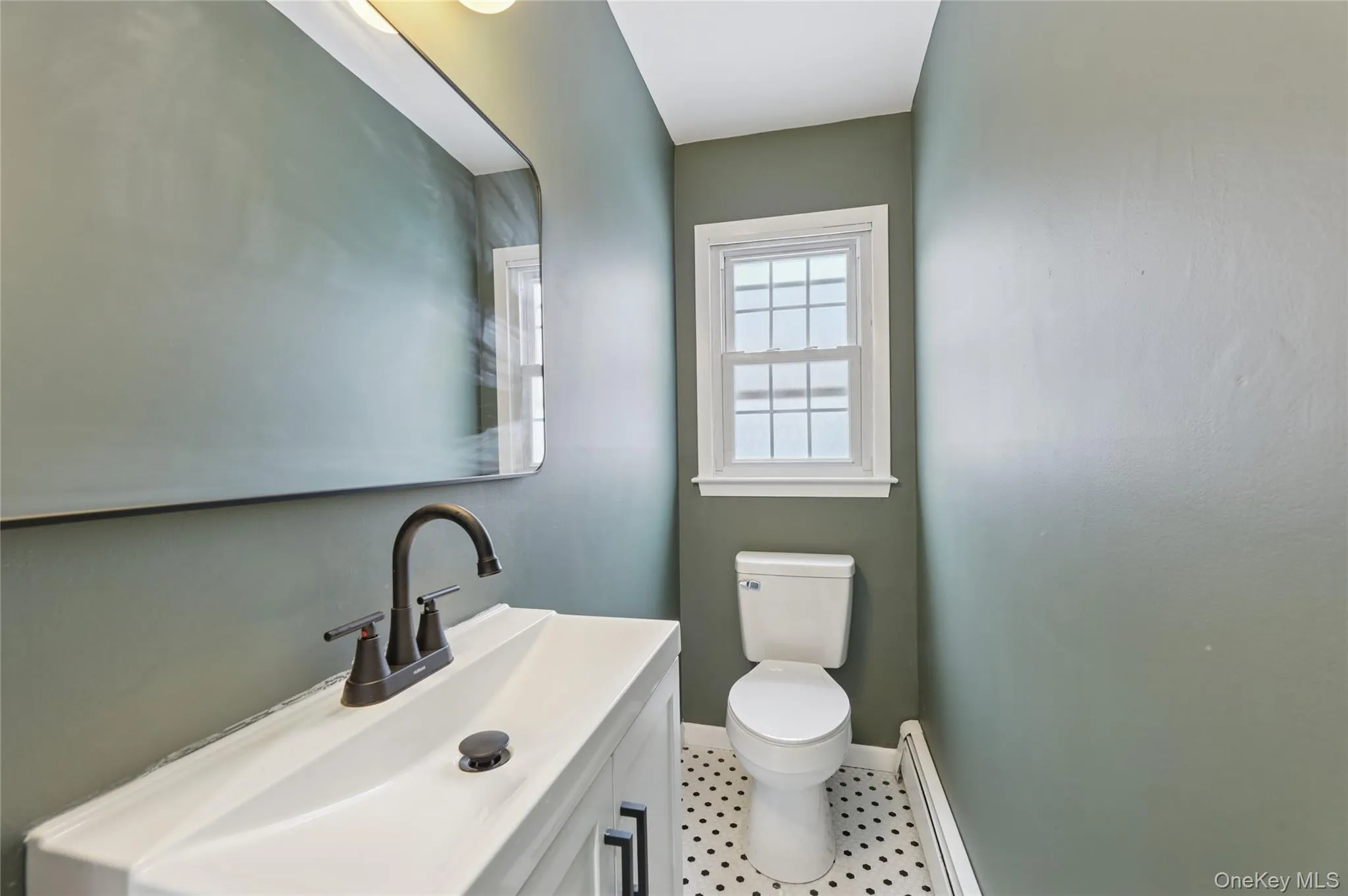 Bathroom featuring a baseboard radiator and vanity Bathroom featuring a baseboard radiator and vanity