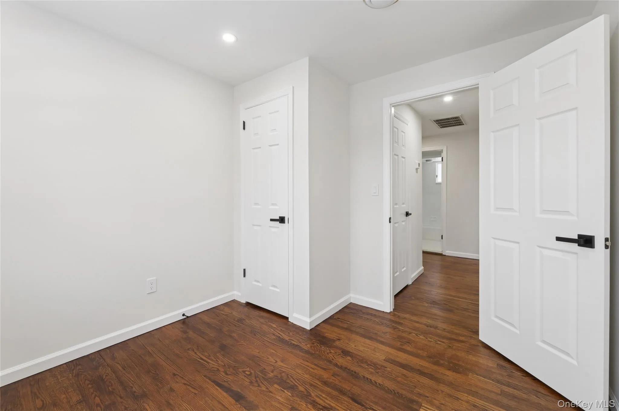 Empty room featuring dark wood-style flooring and recessed lighting Empty room featuring dark wood-style flooring and recessed lighting