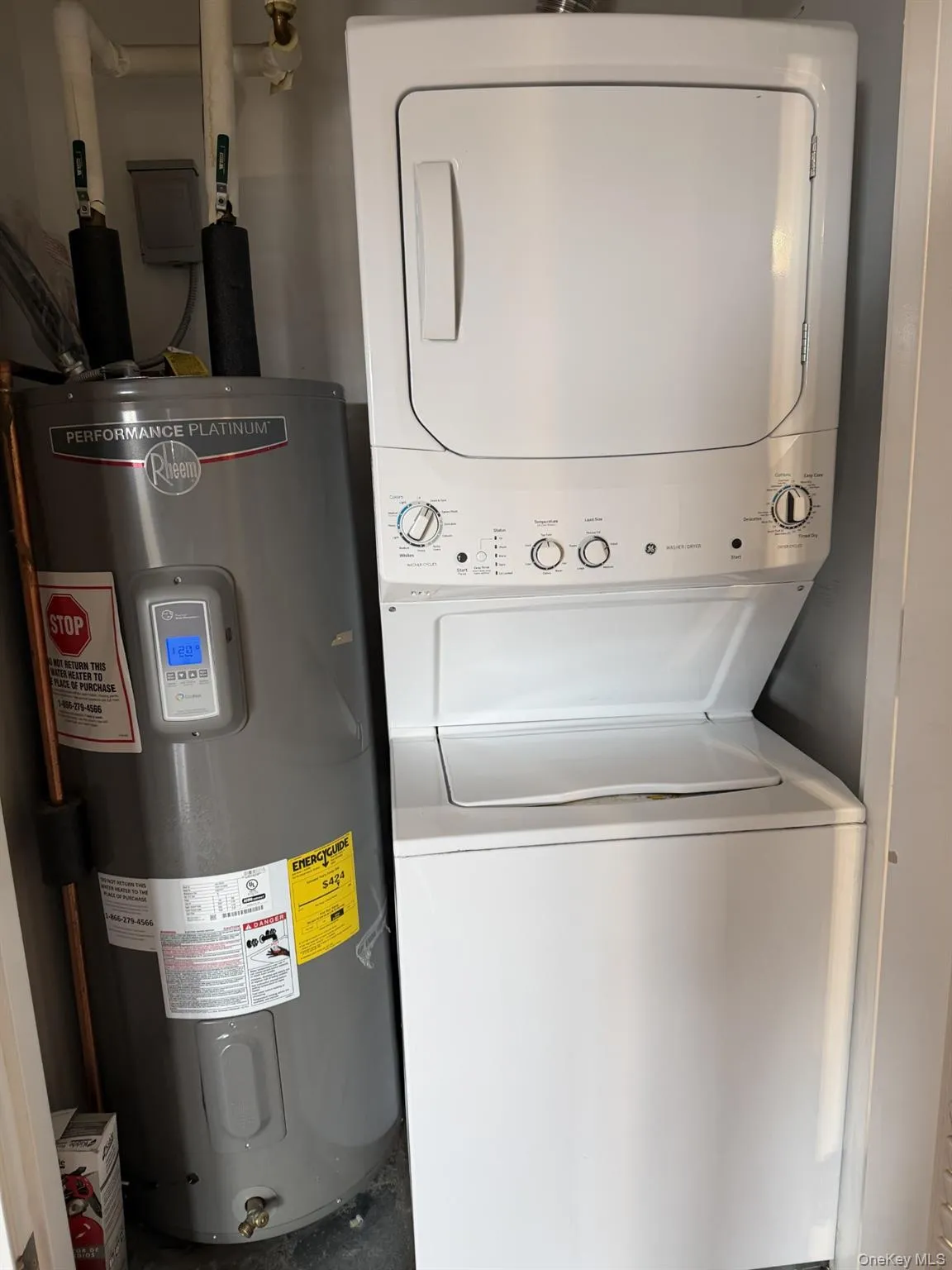 Laundry area with electric water heater and stacked washer / drying machine Laundry area with electric water heater and stacked washer / drying machine