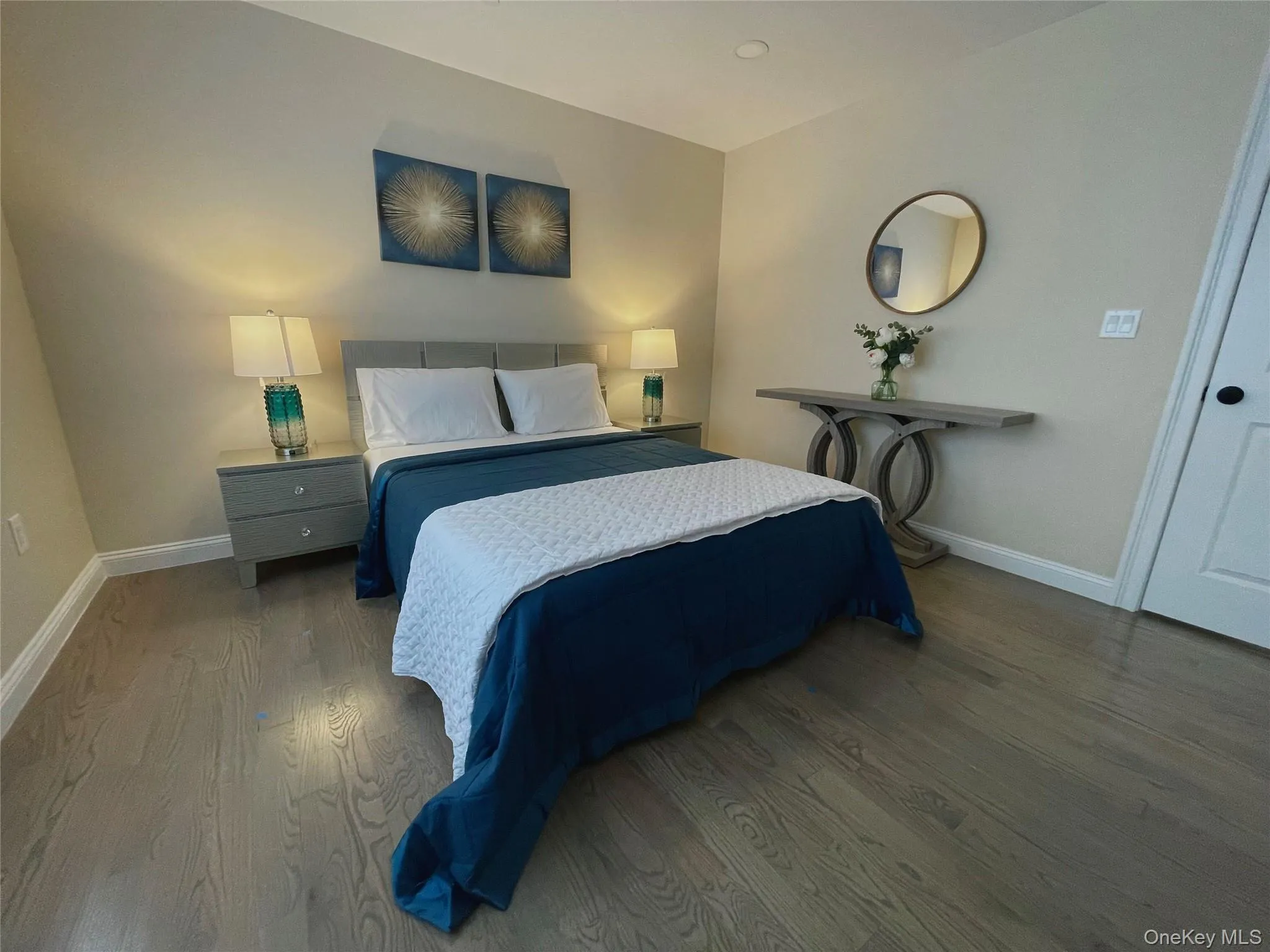 Bedroom featuring wood finished floors and baseboards Bedroom featuring wood finished floors and baseboards