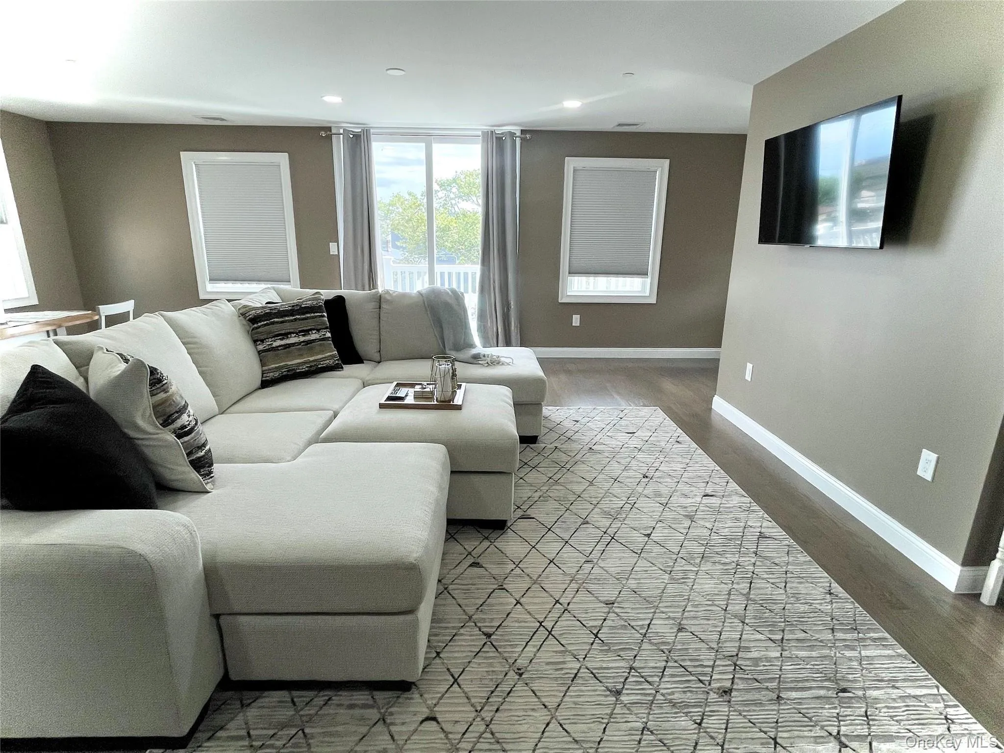 Living room with light wood finished floors and recessed lighting Living room with light wood finished floors and recessed lighting