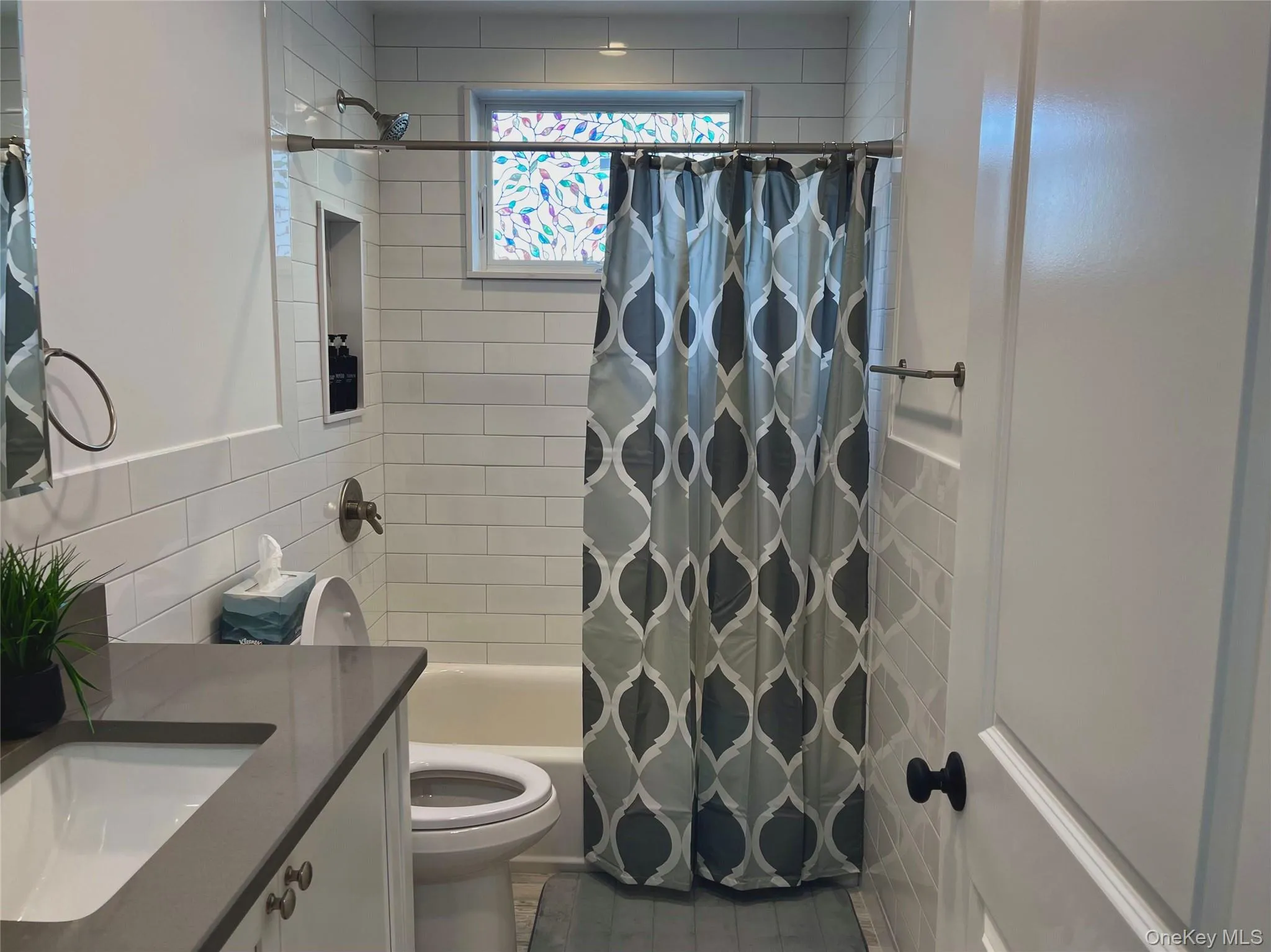 Full bathroom with shower / tub combo, vanity, and tile walls Full bathroom with shower / tub combo, vanity, and tile walls