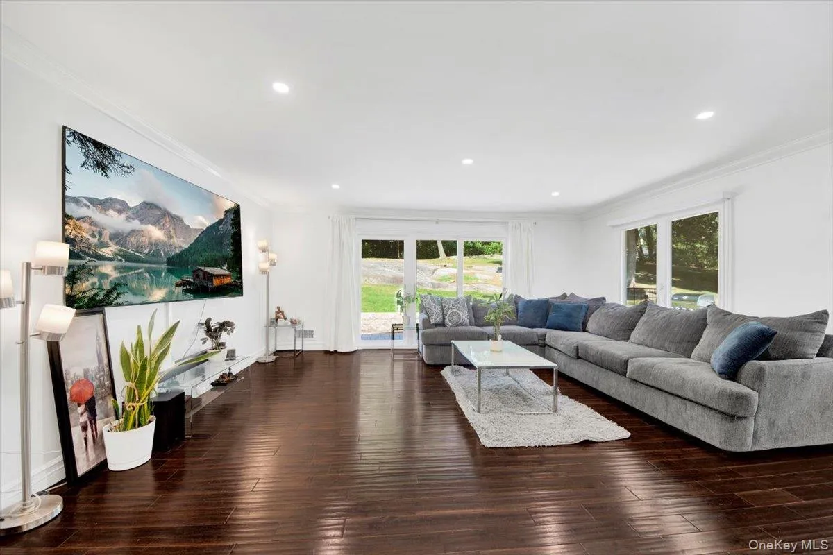 Living area featuring crown molding, wood finished floors, and recessed lighting Living area featuring crown molding, wood finished floors, and recessed lighting