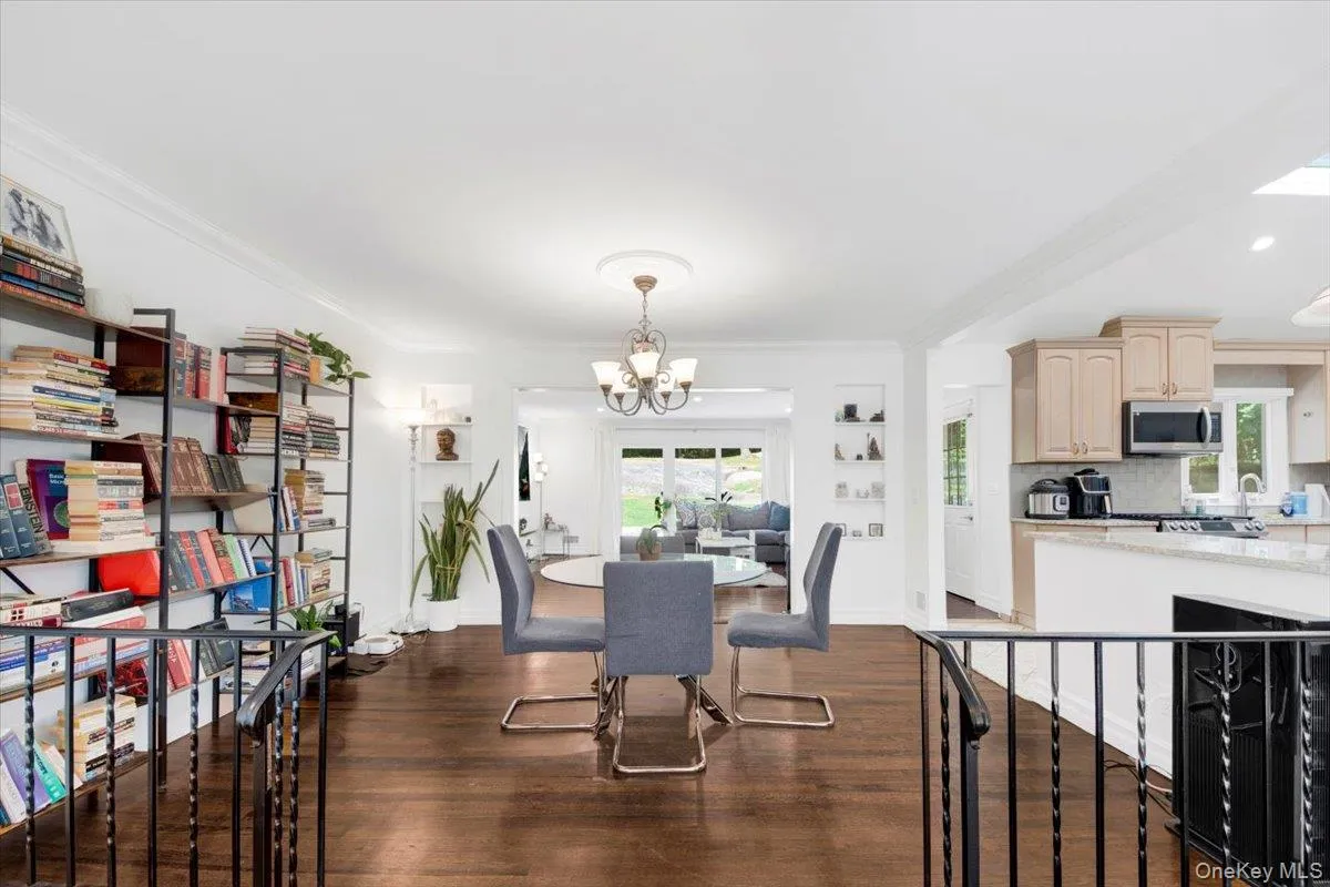 Dining space with dark wood-type flooring, a chandelier, and crown molding Dining space with dark wood-type flooring, a chandelier, and crown molding