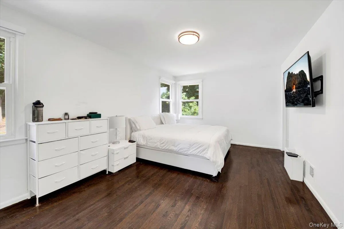 Bedroom featuring baseboards and dark wood-style flooring Bedroom featuring baseboards and dark wood-style flooring