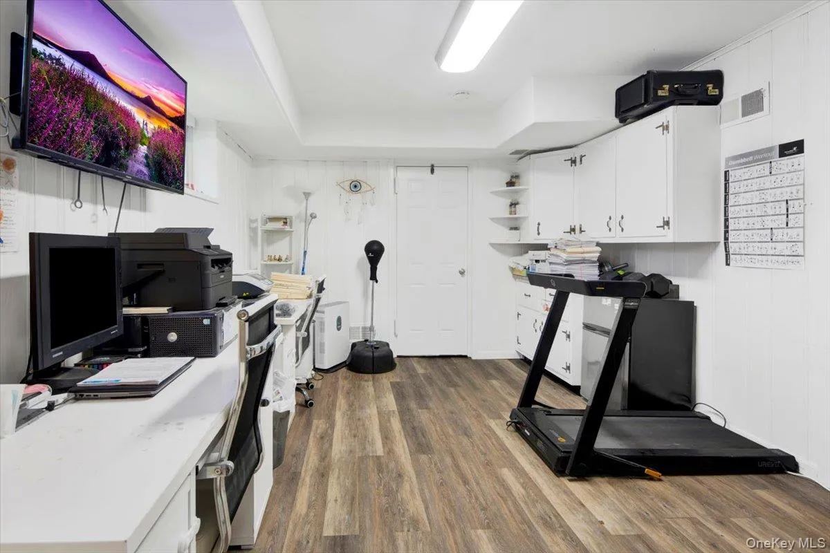 Exercise room featuring wood finished floors and wood walls Exercise room featuring wood finished floors and wood walls