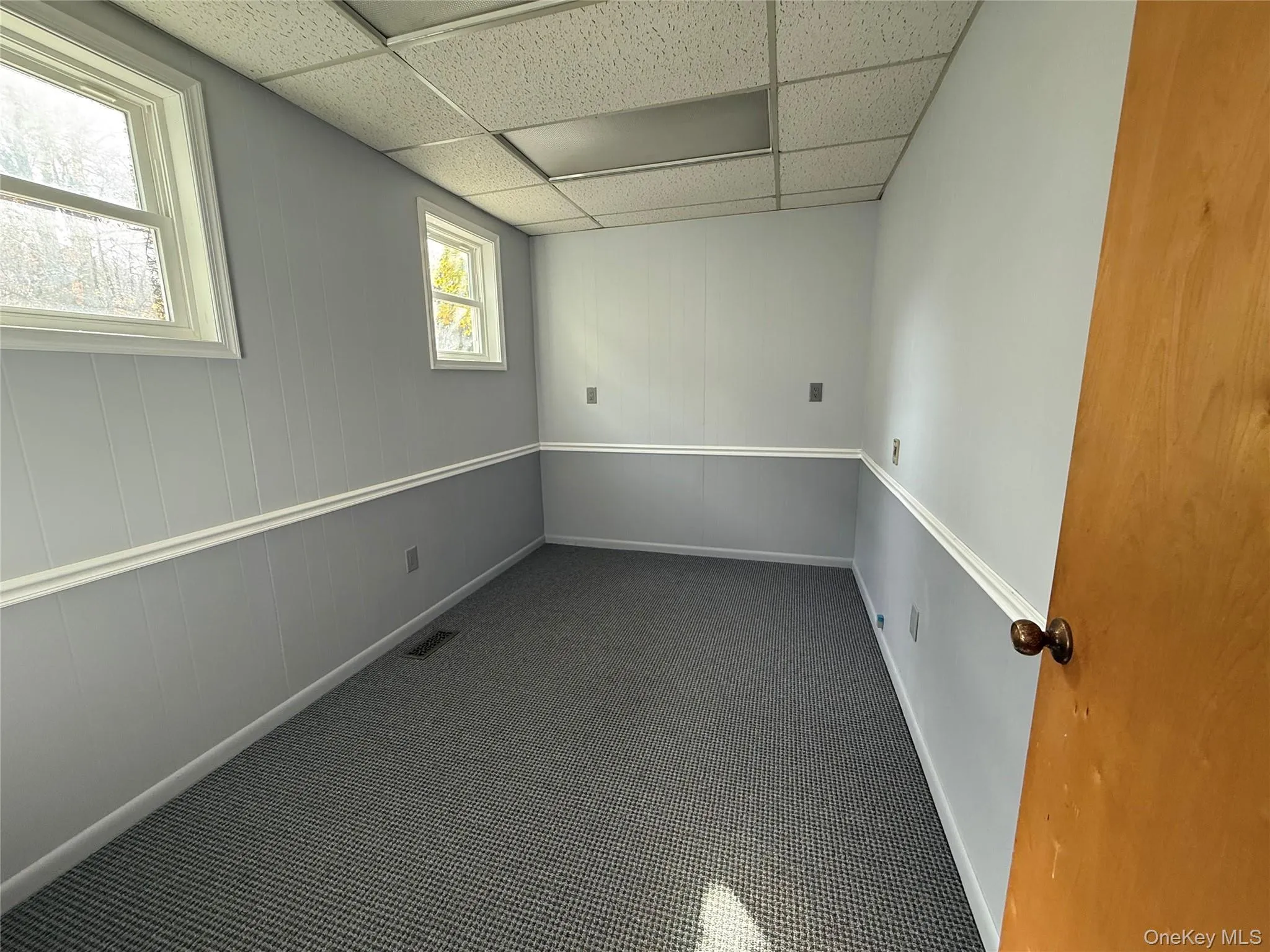 Spare room with a paneled ceiling and dark carpet Spare room with a paneled ceiling and dark carpet