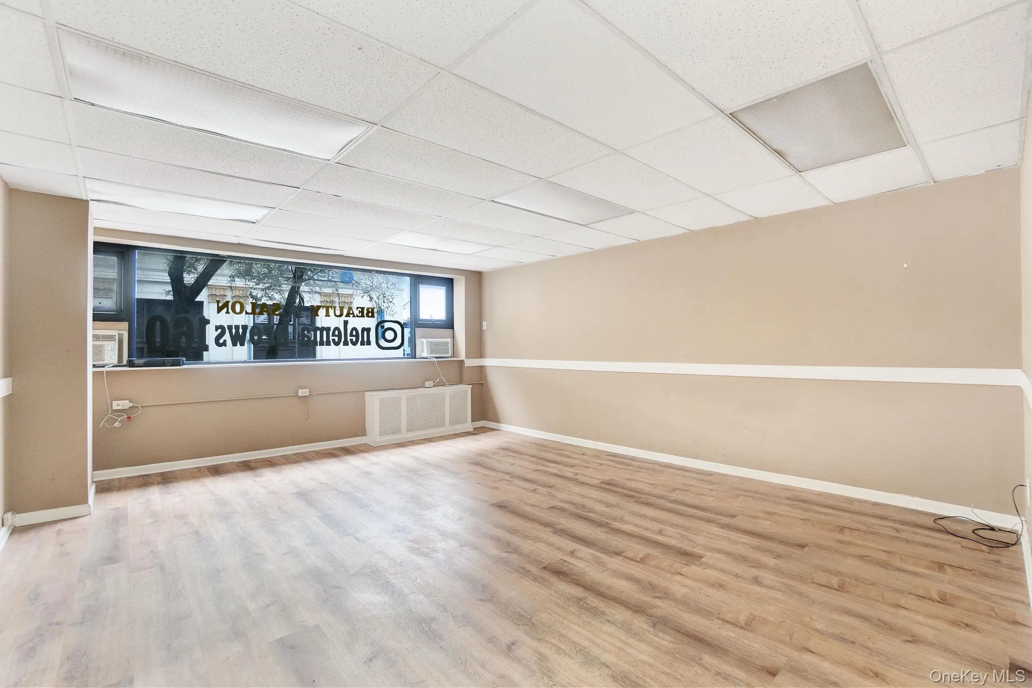 Spare room featuring a paneled ceiling and wood finished floors Spare room featuring a paneled ceiling and wood finished floors