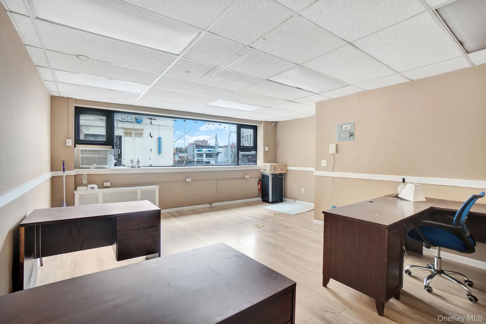Home office with light wood-style floors, a drop ceiling, and cooling unit Home office with light wood-style floors, a drop ceiling, and cooling unit