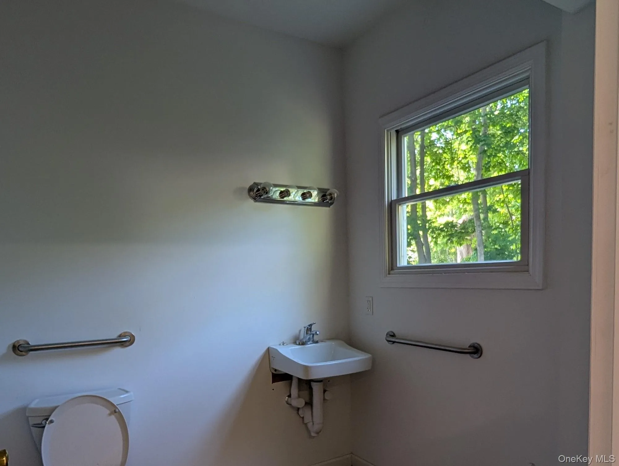 Bathroom featuring toilet and a sink Bathroom featuring toilet and a sink