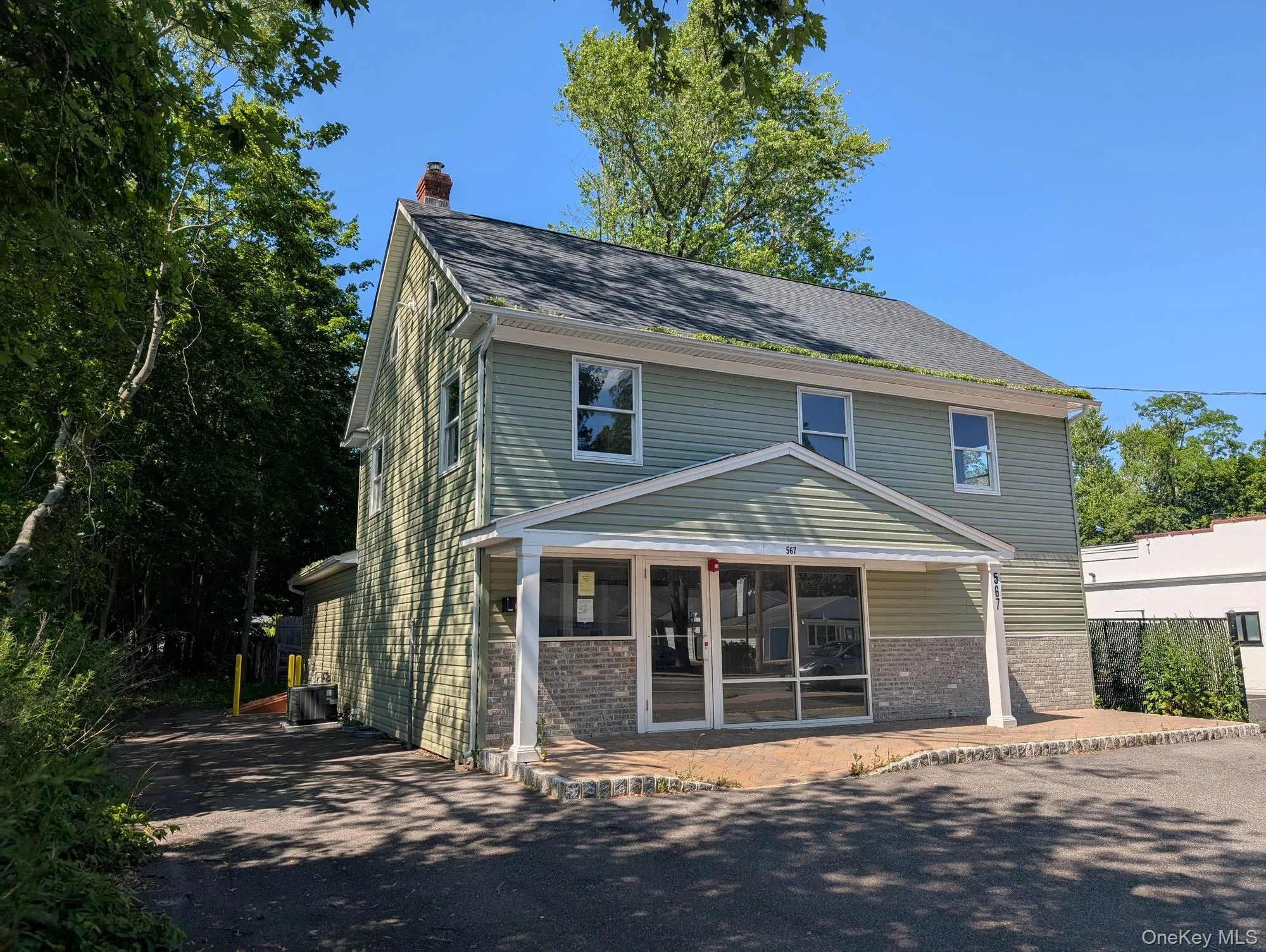 View of front facade featuring brick siding and a chimney View of front facade featuring brick siding and a chimney