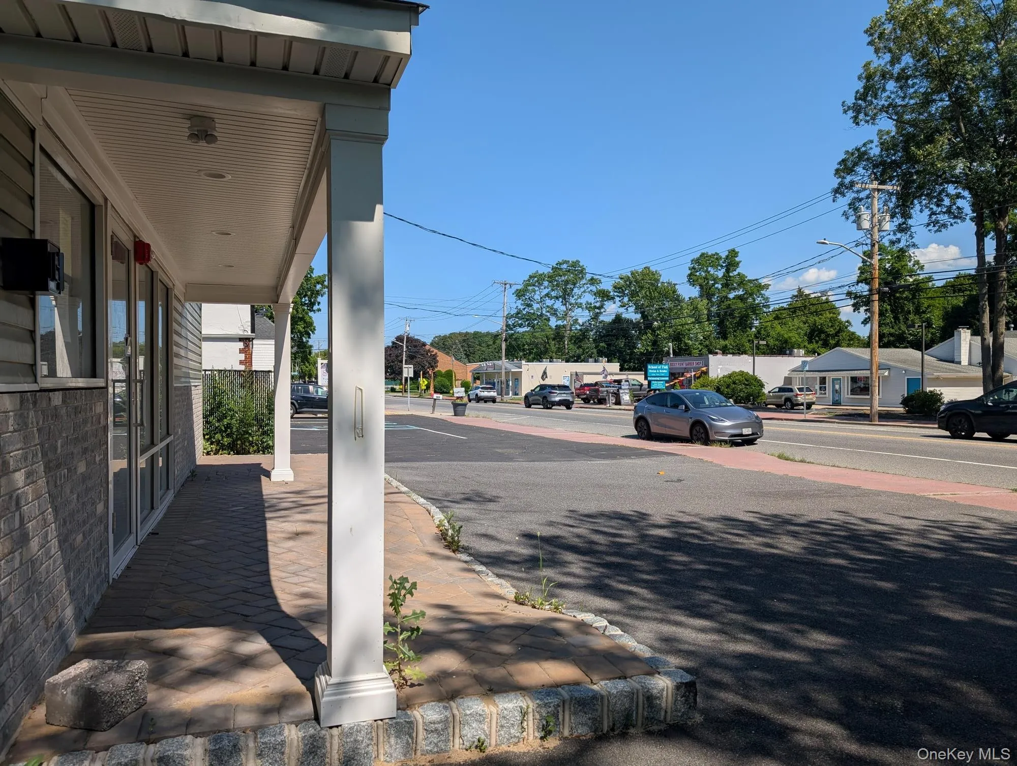 View of asphalt road featuring street lighting, sidewalks, and curbs View of asphalt road featuring street lighting, sidewalks, and curbs
