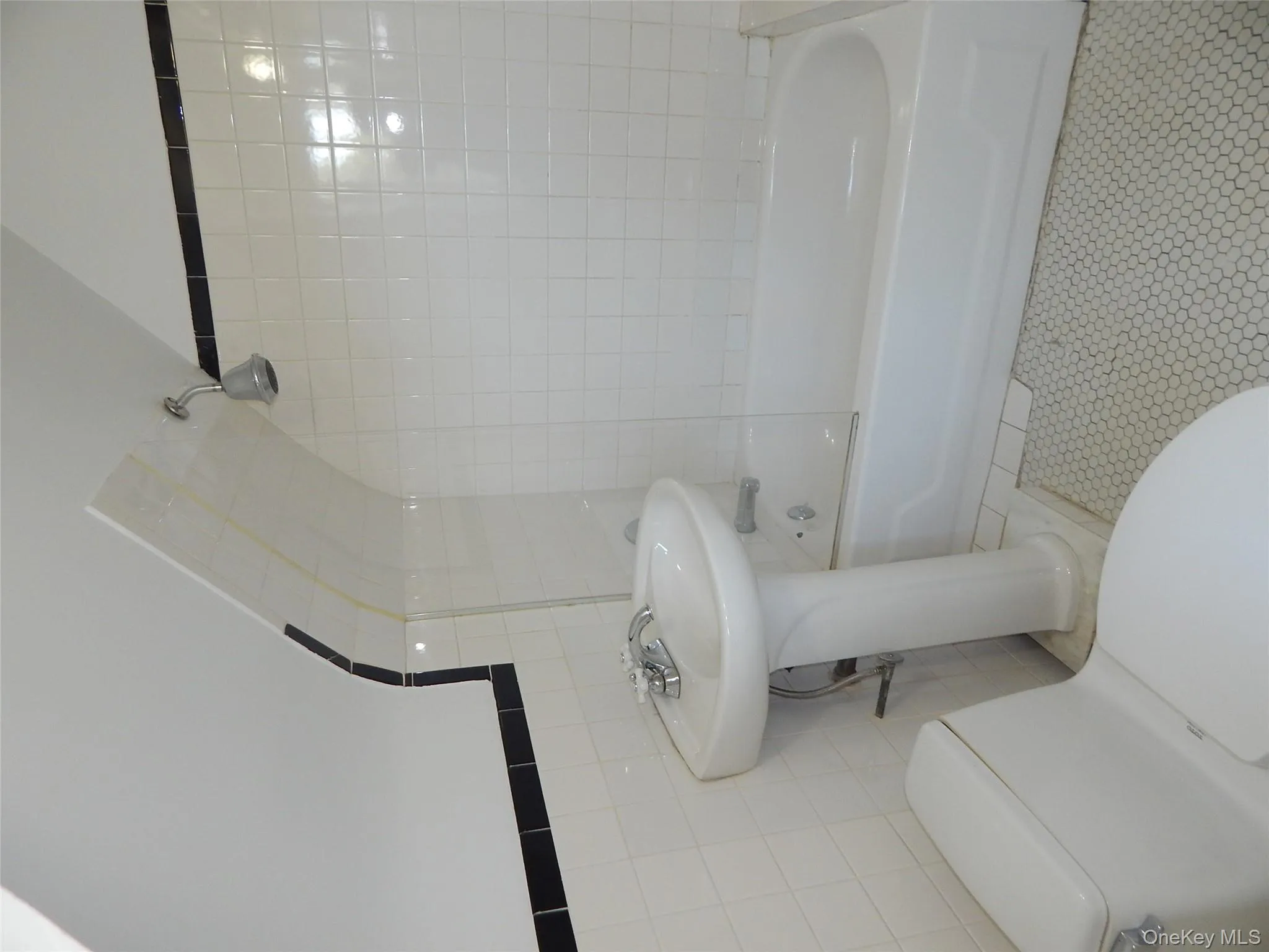 Full bath featuring shower combination, tile patterned floors, and tile walls Full bath featuring shower combination, tile patterned floors, and tile walls