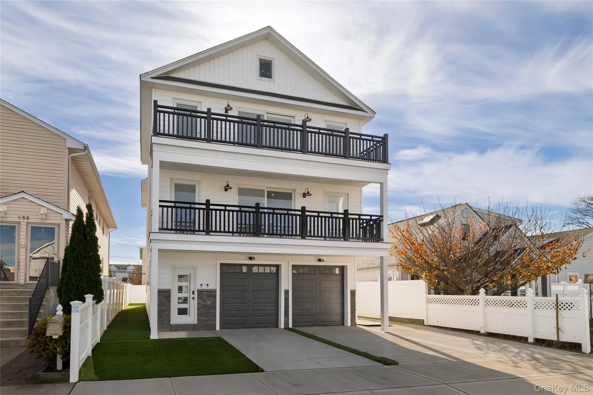 View of front of property with driveway, a garage, a balcony, and board and batten siding View of front of property with driveway, a garage, a balcony, and board and batten siding