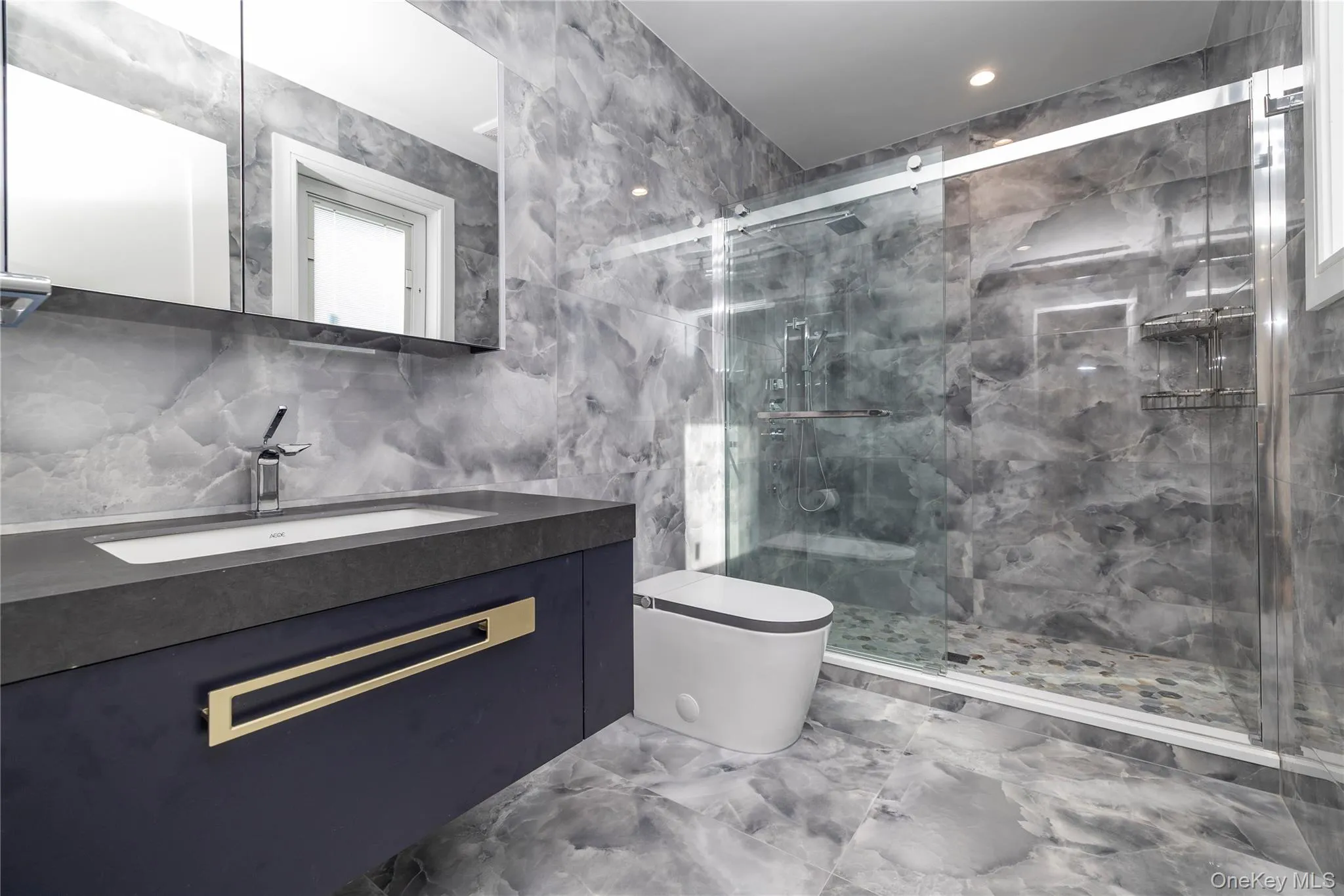 Bathroom with tile walls, marble tiled flooring, vanity, a marble finish shower, and decorative backsplash Bathroom with tile walls, marble tiled flooring, vanity, a marble finish shower, and decorative backsplash