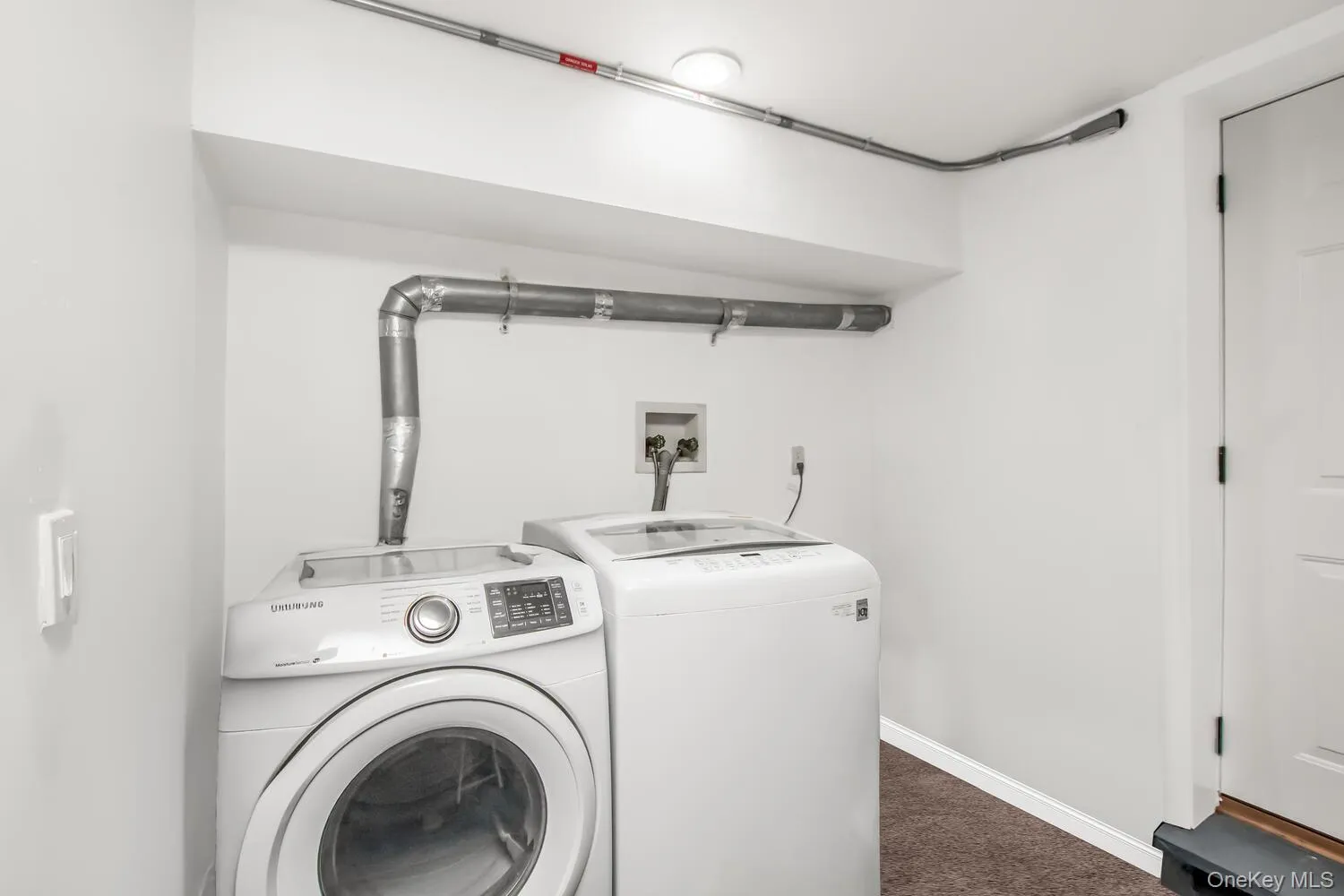 Washroom with dark carpet, washer and dryer, and baseboards Washroom with dark carpet, washer and dryer, and baseboards