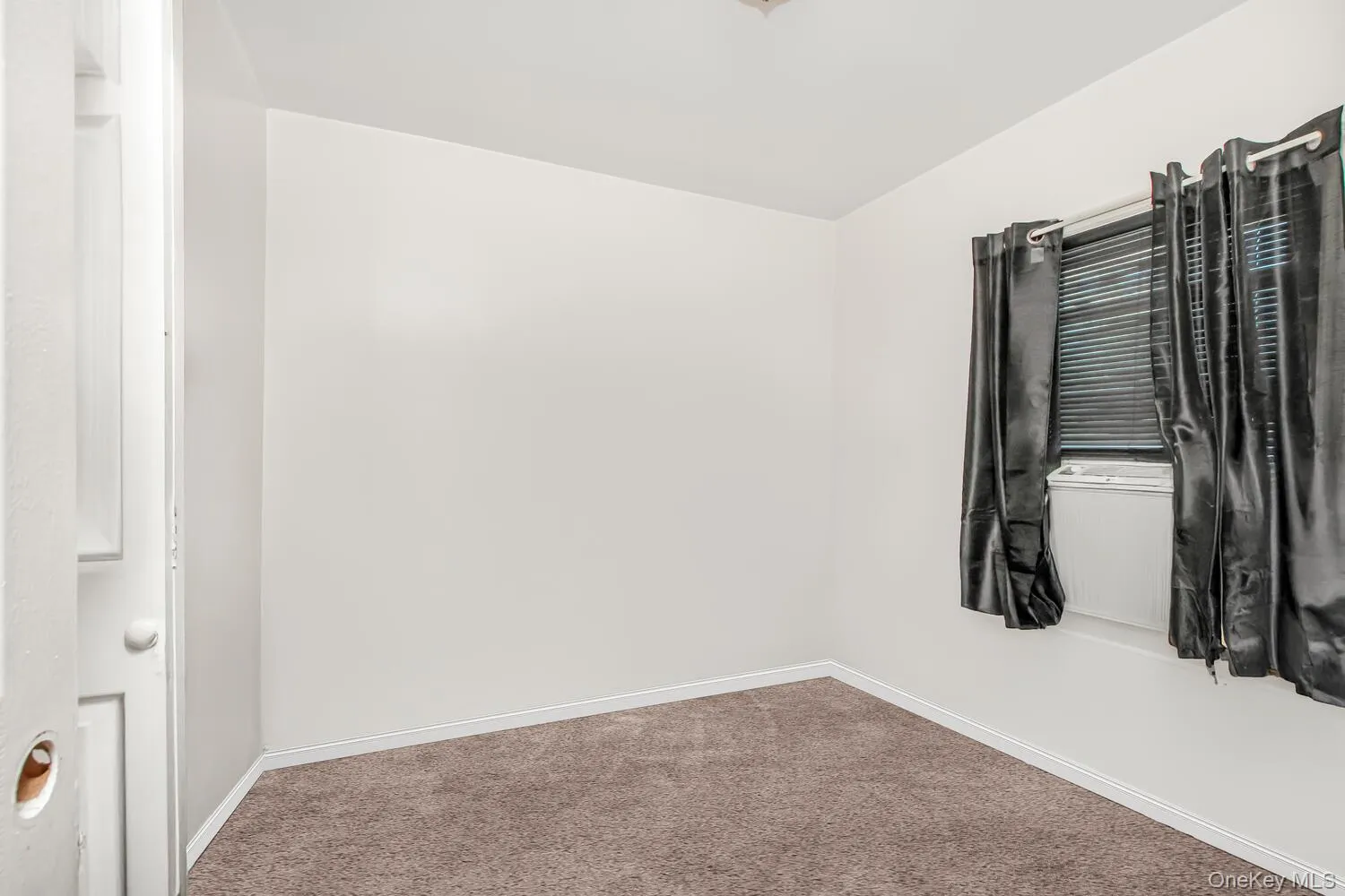Spare room featuring carpet floors and baseboards Spare room featuring carpet floors and baseboards