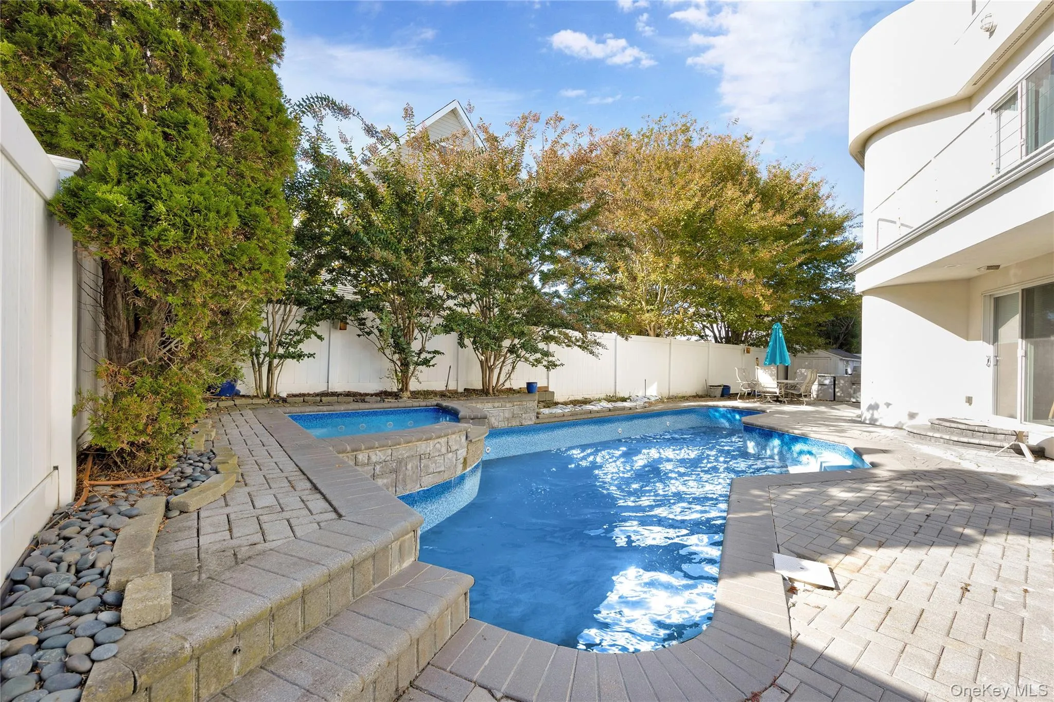 View of swimming pool with a patio area, a fenced backyard, and a pool with connected hot tub View of swimming pool with a patio area, a fenced backyard, and a pool with connected hot tub