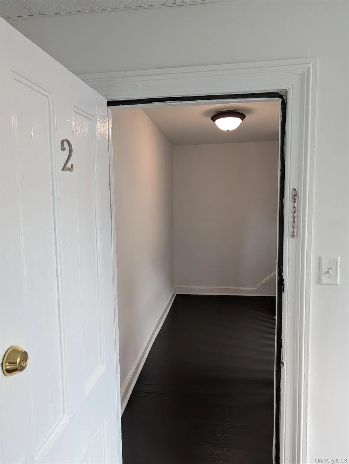 Hall featuring dark wood-style floors and baseboards Hall featuring dark wood-style floors and baseboards