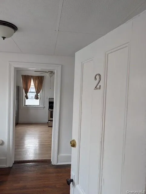 Hallway with dark wood finished floors and a textured ceiling Hallway with dark wood finished floors and a textured ceiling