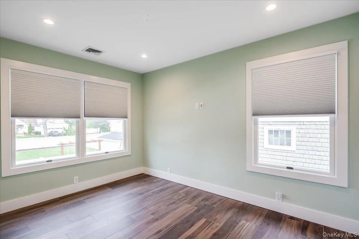 Spare room featuring dark wood-type flooring and recessed lighting Spare room featuring dark wood-type flooring and recessed lighting