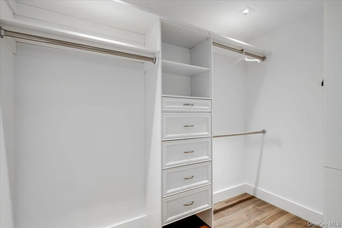 Walk in closet with light wood finished floors Walk in closet with light wood finished floors