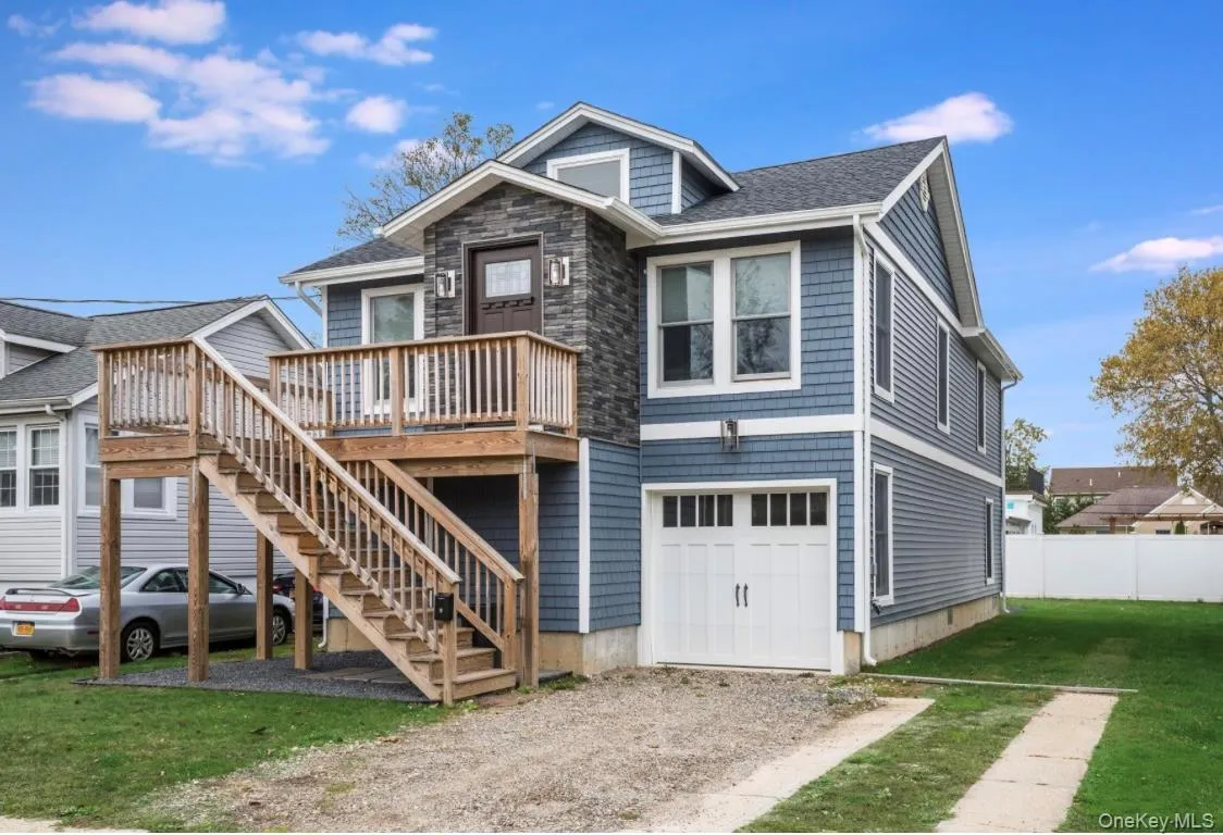 View of front of house featuring a deck, a shingled roof, stairway, an attached garage, and driveway View of front of house featuring a deck, a shingled roof, stairway, an attached garage, and driveway