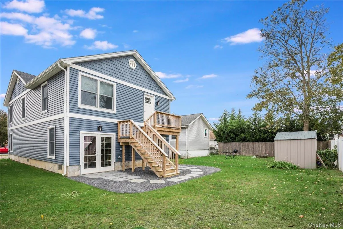Back of property with stairs, a fenced backyard, a storage shed, a patio, and french doors Back of property with stairs, a fenced backyard, a storage shed, a patio, and french doors