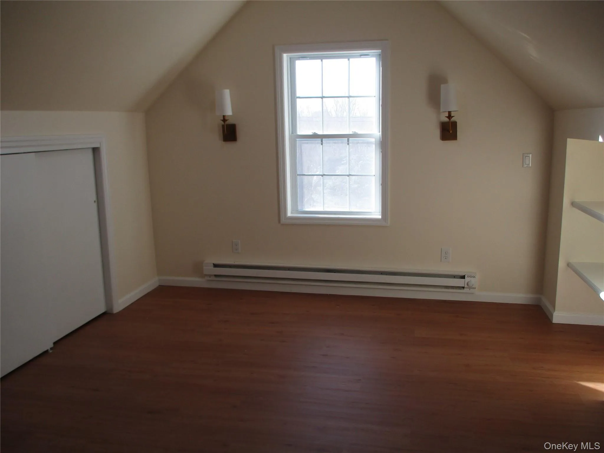 Additional living space featuring dark wood-type flooring, baseboard heating, and vaulted ceiling Additional living space featuring dark wood-type flooring, baseboard heating, and vaulted ceiling