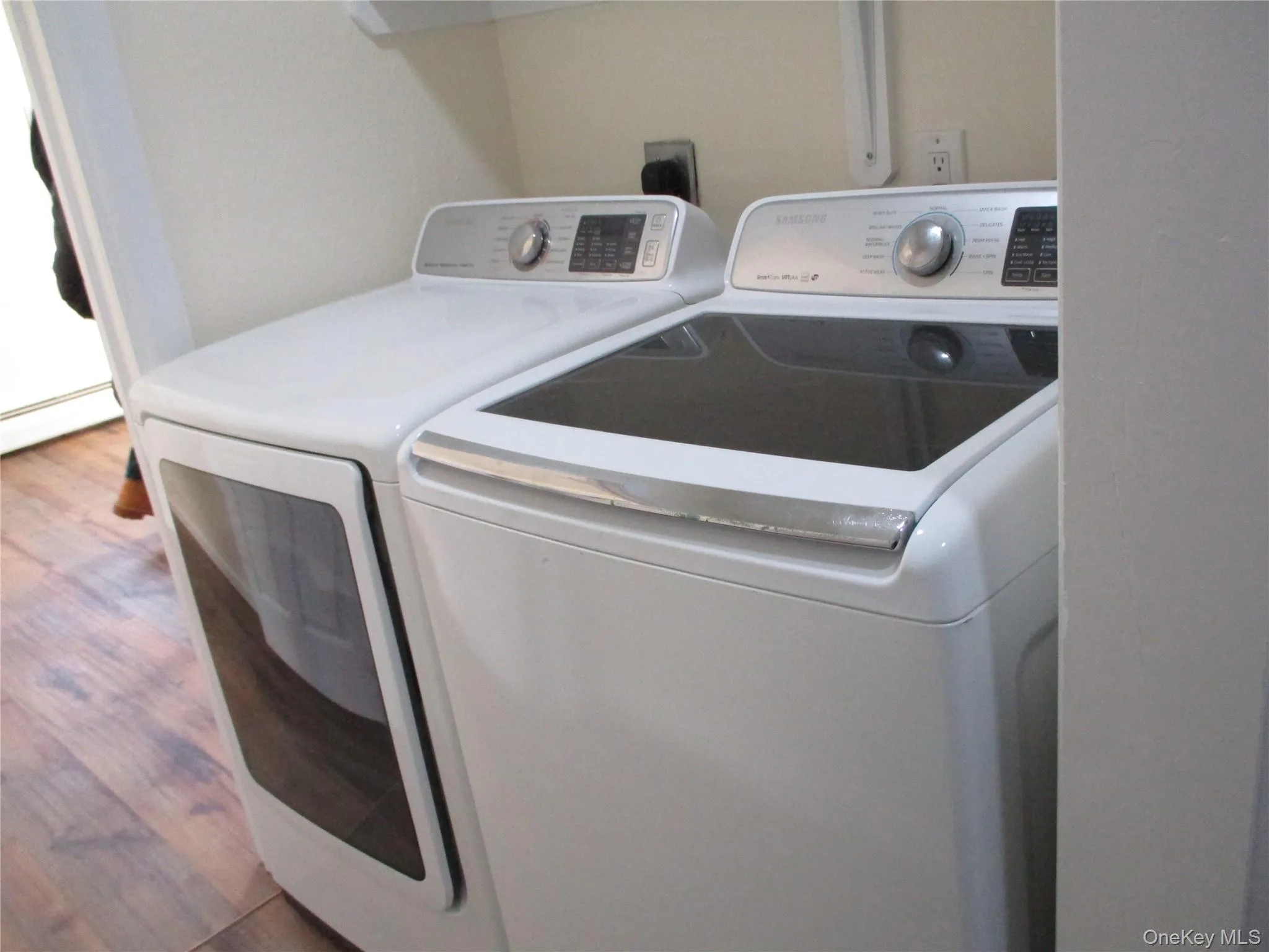 Laundry room featuring washer and clothes dryer and wood finished floors Laundry room featuring washer and clothes dryer and wood finished floors
